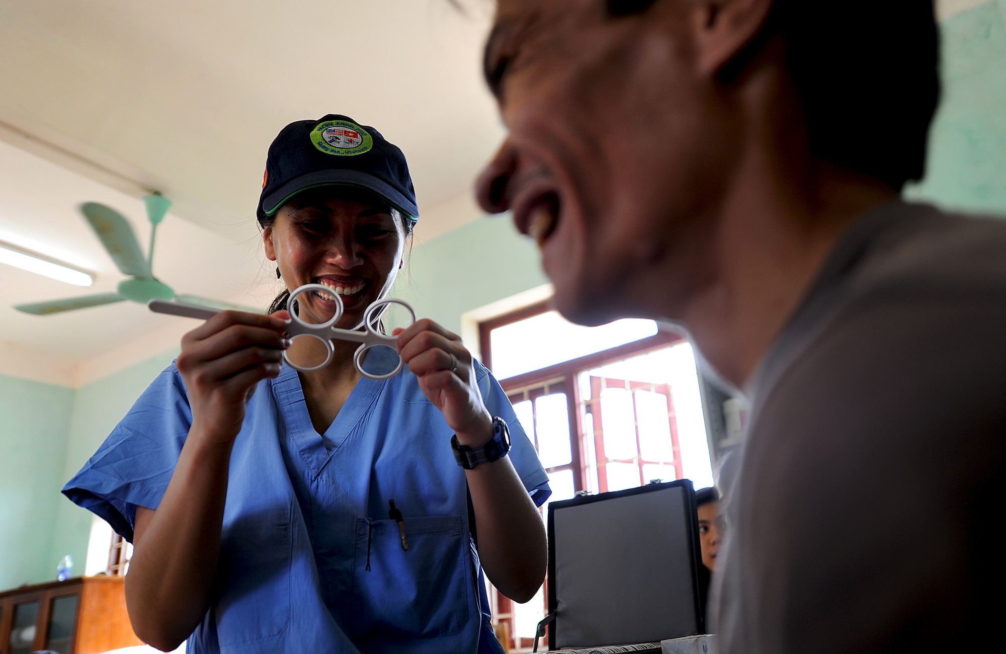 Capt. Alexandra Tran, optometrist from Grand Forks Air Force Base, N.D., examines a patient's eyes as part of Health Service Outreach Program during Operation Pacific Angel 13-3 in Dong Hoi, Quang Binh Province, Vietnam, June 10, 2013. Optometry was one of the various medical services offered as part of the Health Services Outreach program during the reoccurring humanitarian mission. Operation PACANGEL is a joint and combined humanitarian assistance exercise held in various countries several times a year and includes medical, dental, optometry, engineering programs and a variety of subject-matter expert exchanges. (U.S. Air Force photo by Staff Sgt. Sara Csurilla)