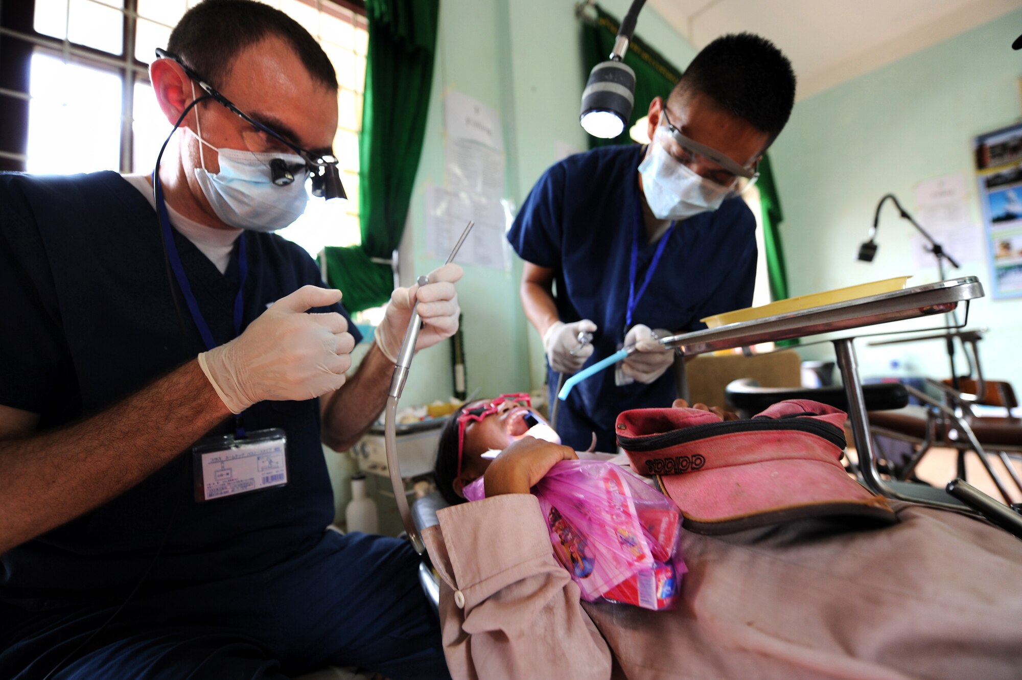 U.S. Air Force Capt. Jon Harmon, dentist from the 35th Dental Squadron at Yokota Air Base, Japan, performs dental procedures on a Vietnamese child's teeth as part of the Health Service Outreach Program during Operation Pacific Angel 13-3 in Dong Hoi, Quang Binh Province, Vietnam, June 15, 2013. Dental services was one of the various medical services offered as part of the HSO program during the reoccurring humanitarian mission. Operation PACANGEL is a joint and combined humanitarian assistance exercise held in various countries several times a year and includes medical, dental, optometry, engineering programs and a variety of subject-matter expert exchanges. (U.S. Air Force photo by Staff Sgt. Sara Csurilla)