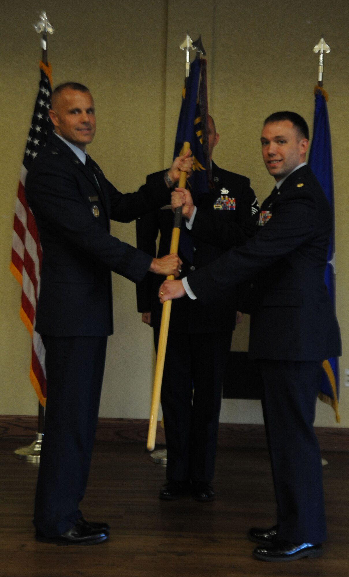 Brig. Gen Brad Spacy, 81st Training Wing commander, exchanges the guidon with Maj. Jayson Cabell, incoming 81st Comptroller Squadron commander, as he assumes command during the 81st CPTS change of command ceremony June 17, 2013, at the Bay Breeze Event Center, Keesler Air Force Base, Miss.  Maj. Phelemon Williams, outgoing 81st CPTS commander, relinquished his command to Cabell and Spacy served as the presiding officer for the event. (U.S. Air Force photo by Airman 1st Class Stephan Coleman)
