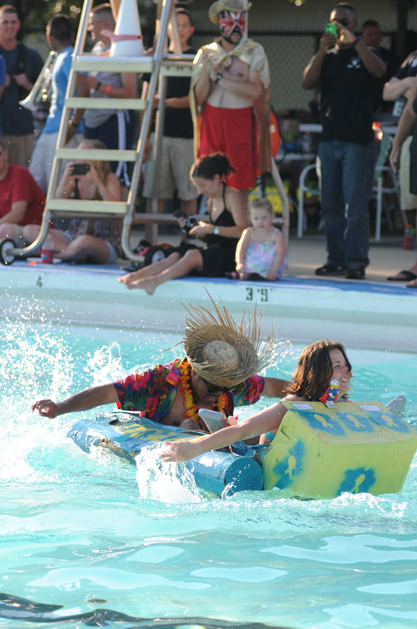 Airmen 1st Class Ronnie Hayden and Kejdi Memetaj, 81st Diagnostic and Therapeutics Squadron, paddle their vessel, Lab Rats, to the finish line during the cardboard boat regatta June 15, 2013, at the Triangle Pool, Keesler Air Force Base, Miss.  There were 18 participants total in the event.  (U.S. Air Force photo by Kemberly Groue)