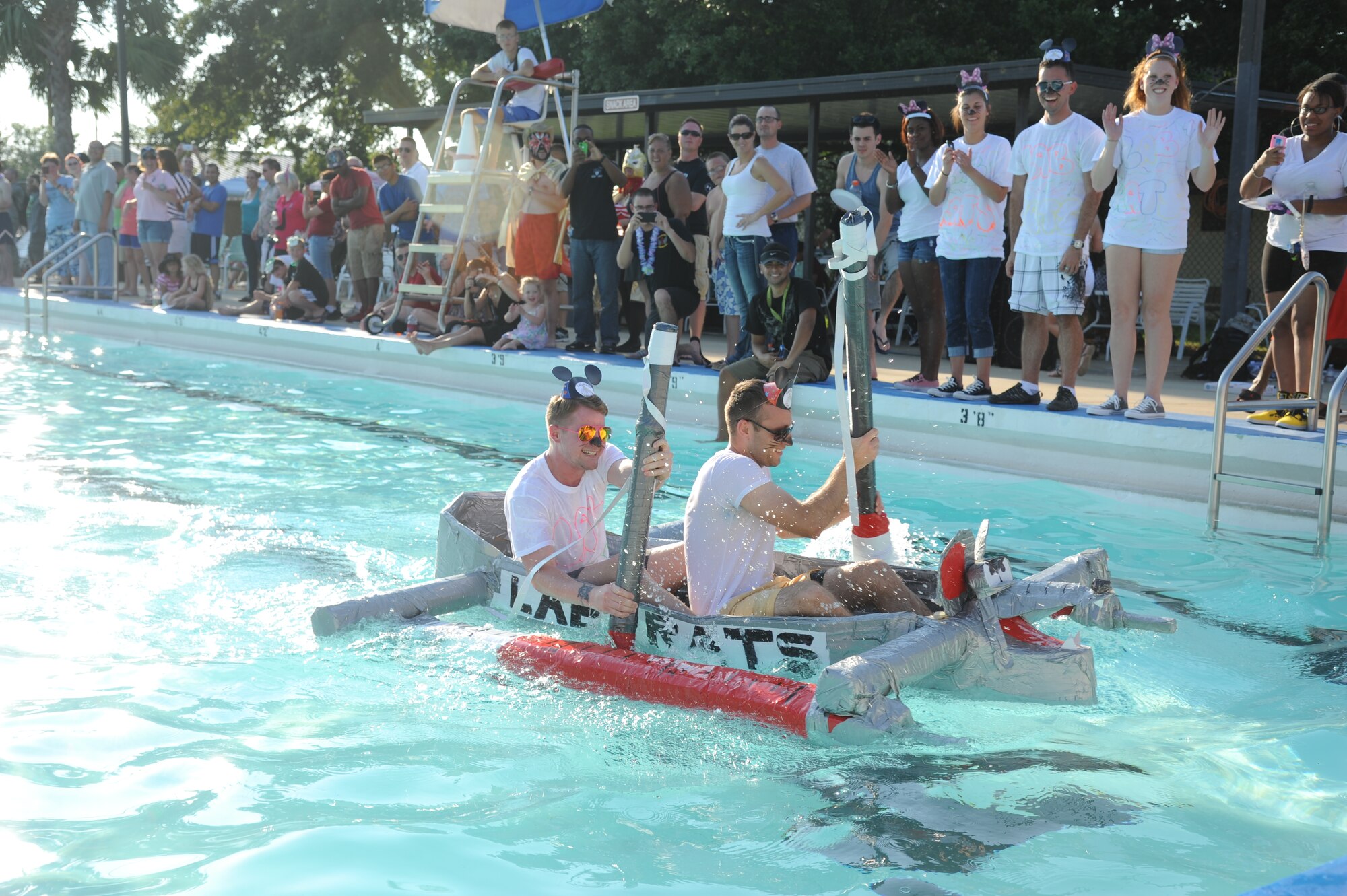 Airmen 1st Class Ronnie Hayden and Kejdi Memetaj, 81st Diagnostic and Therapeutics Squadron, paddle their vessel, Lab Rats, to the finish line during the cardboard boat regatta June 15, 2013, at the Triangle Pool, Keesler Air Force Base, Miss.  There were 18 participants total in the event.  (U.S. Air Force photo by Kemberly Groue)