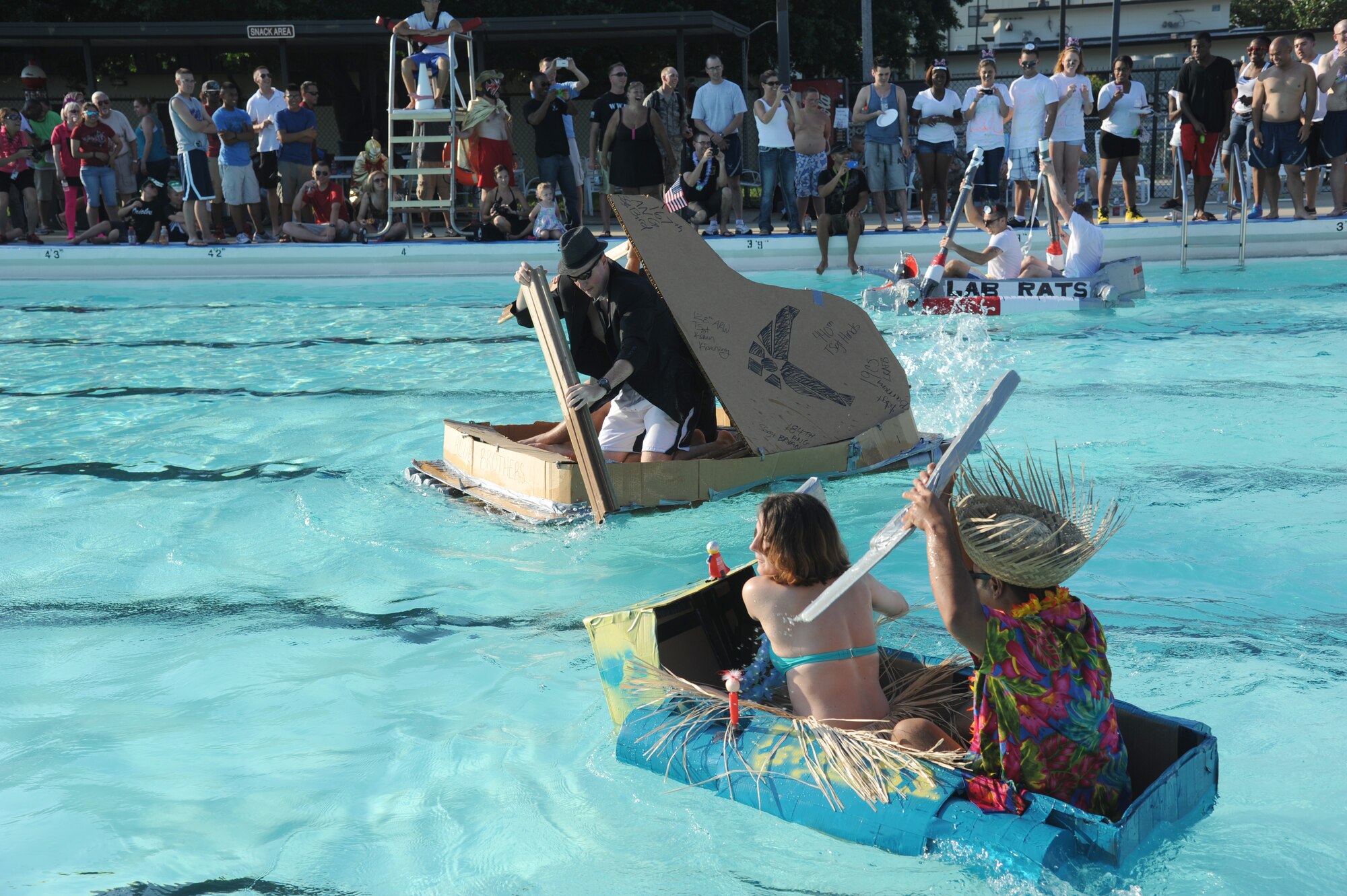 Cardboard boaters race across the pool during the cardboard boat regatta June 15, 2013, at the Triangle Pool, Keesler Air Force Base, Miss.  There were 18 participants total in the event.  (U.S. Air Force photo by Kemberly Groue)