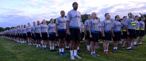 Soldiers stand at attention before marching to the starting line for both the Army and Training and Doctrine Command's celebratory birthday run, June 14, 2013 at Fort Eustis, Va. Units from across the base ran in the event, each carrying their respective unit flags. (U.S. Air Force photo by Airman 1st Class Austin Harvill/Released)