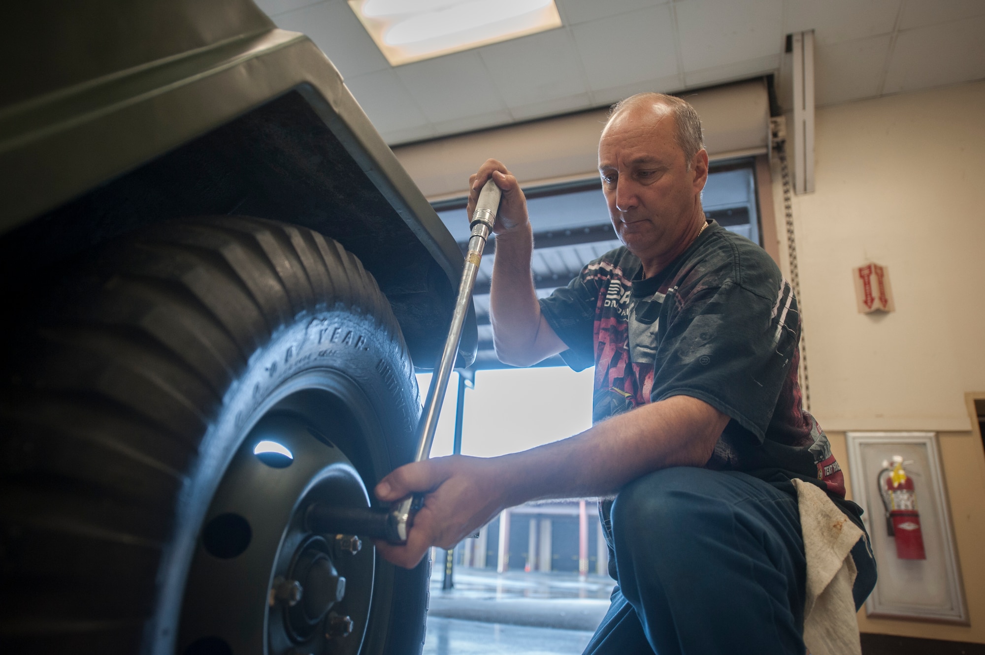 John Zakar, 23d Logistics Readiness Squadron service writer, kneels down to check the tail light on a 1967 M151 jeep at Moody Air Force Base, Ga., May 31, 2013. Zakar got the ambulance running in 2000 and has maintained it ever since. (U.S. Air Force photo by Airman 1st Class Sandra Marrero/released)  