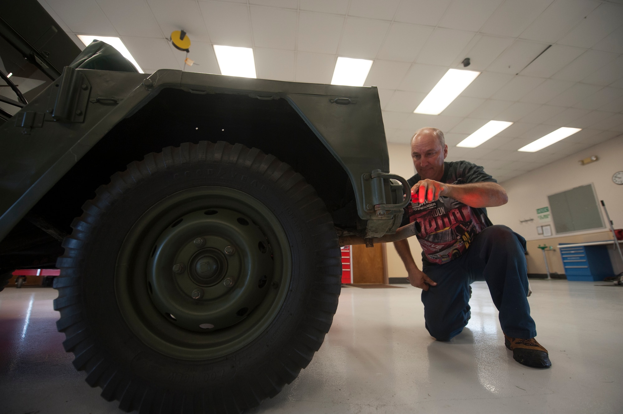 John Zakar, 23d Logistics Readiness Squadron service writer, kneels down to check the tail light on a 1967 M151 jeep at Moody Air Force Base, Ga., May 31, 2013. Zakar got the ambulance running in 2000 and has maintained it ever since. (U.S. Air Force photo by Airman 1st Class Sandra Marrero/released)  