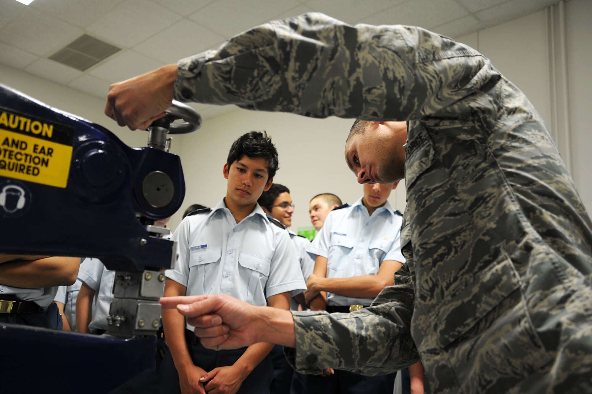 Tech. Sgt. Justin Danieli, 92nd Maintenance Squadron, aircraft structural maintenance craftsman, shows the Royal Canadian Air Cadets how to operate a shrinking and stretching machine during a base tour at Fairchild Air Force Base, Wash., June 7, 2013. The cadets received a base tour, which included stops at the headquarters building, the dining facility, maintenance shops, the flightline, aerospace physiology and Air Heritage Park. (U.S. Air Force photo by Senior Airman Earlandez Young/Released)