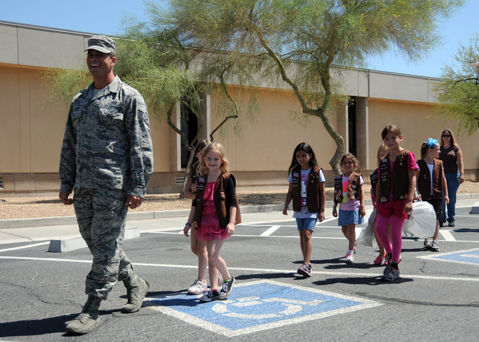 Staff Sgt. Derrick Lehner, 944th Fighter Wing Chaplains Assistant, leads Girl Scout Troop 425 Arizona Cactus Pine around Luke AFB during their community service project Jun 1. (U.S. Air Force photo/Staff Sgt. Josh Nason) 