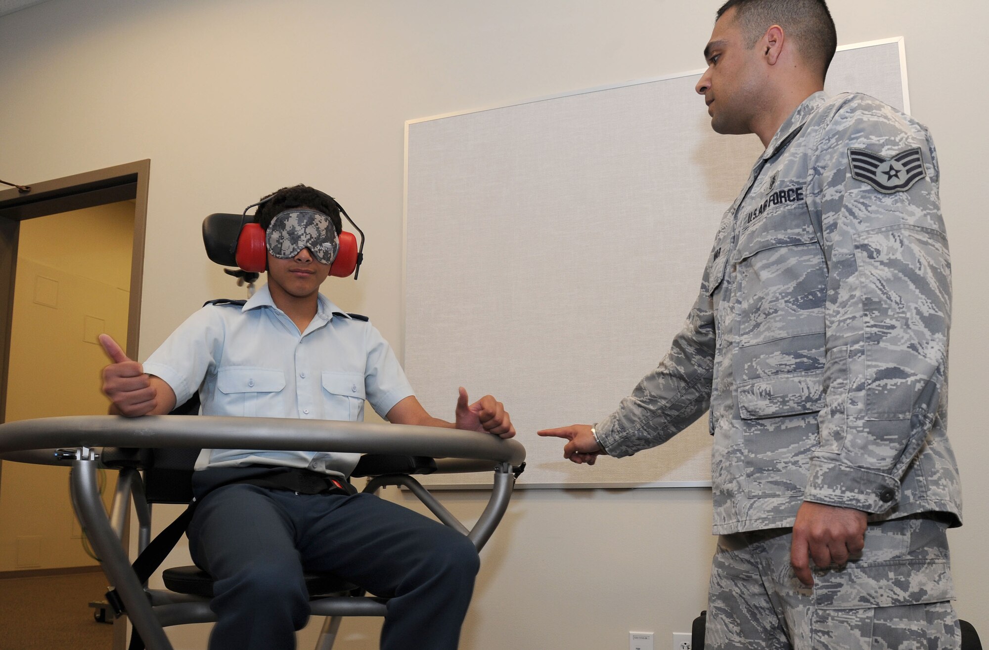 Staff Sgt. Vikas Kumar, 92nd Aerospace Medicine Squadron aerospace and operational physiology, non-commissioned officer in charge, spins a Royal Canadian Air Cadet on the Barany chair while his eyes and ears are covered during a base tour at Fairchild Air Force Base, Wash., June 7, 2013. The Barany chair is a training tool that helps Airmen understand spatial disorientation and learn to trust their instruments. (U.S. Air Force photo by Airman 1st Class Airman 1st Class Janelle Patiño/Released)