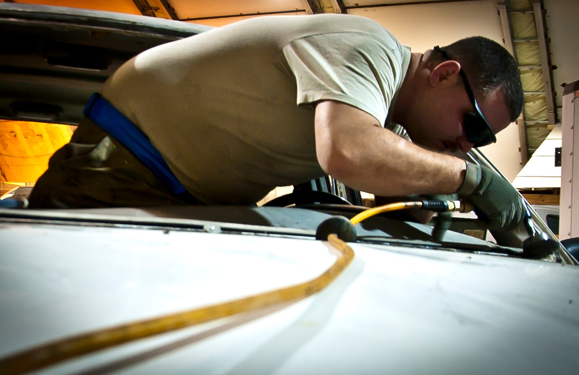 U.S. Air Force Senior Airman David Seeloff, forward deployed to the 451st Expeditionary Logistics Readiness Squadron from the Transit Center at Manas, Kyrgyzstan, removes obstructions before installing a window on a government-owned vehicle at Kandahar Airfield, Afghanistan, May 29, 2013. Seeloth is deployed from the 19th Logistics Readiness Squadron at Little Rock AFB, Ark. (U.S. Air Force photo/Senior Airman Scott Saldukas)