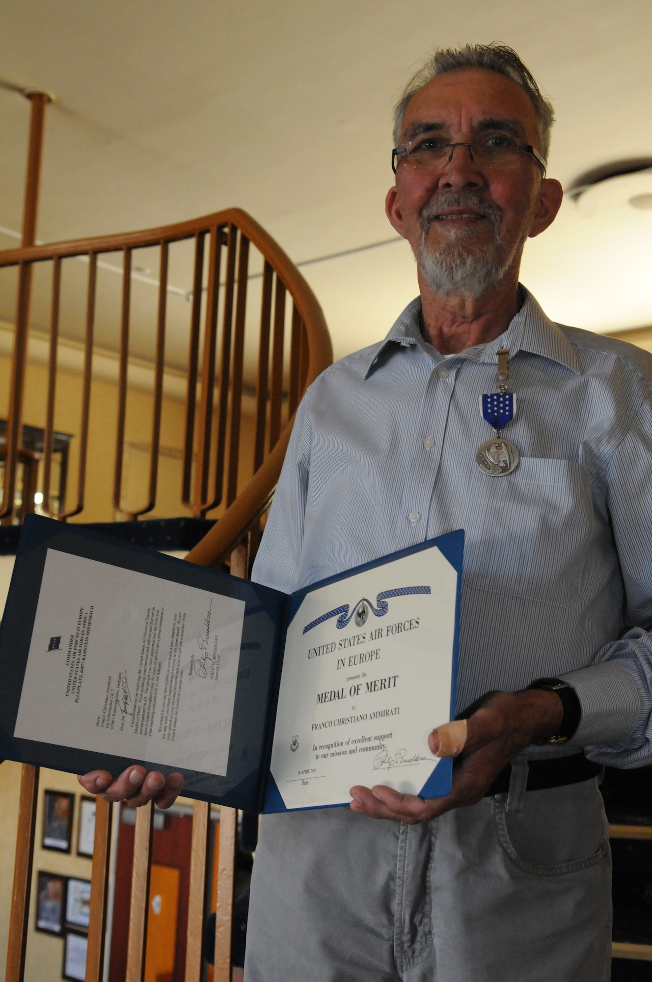 RAMSTEIN AIR BASE, GERMANY -- Franco Ammirati, a retired civilian employee, displays his Medal of Merit inside Armstrong's Club here June 6, 2013. Ammirati received the MOM on May 3 during a small ceremony at U.S. Air Forces in Europe Headquarters here for 50-years of service to the men and women of USAFE. The medal is the second highest honor non-U.S. citizen employees may receive from the command. Ammirati said receiving the medal was the highlight of his career. U.S. Air Force Photo by Tech. Sgt. James M. Hodgman 