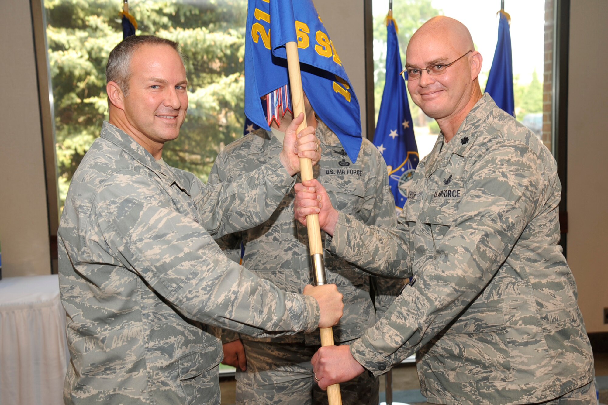 PETERSON AIR FORCE BASE, Colo. – The 16th Space Control Squadron changed command June 13 at The Club. Lt. Col. Paul Tombarge (left), 21st Operations Group commander, transferred command to Lt. Col. Mark Guerber (right), incoming 16th SPCS commander. Guerber takes over the squadron from outgoing commander Lt. Col. Roger Sherman. The 16th SPCS is Air Force Space Command's first defensive counterspace unit and employs the Rapid Attack, Identification, Detection and Reporting System. (U.S. Air Force photo/Robb Lingley)