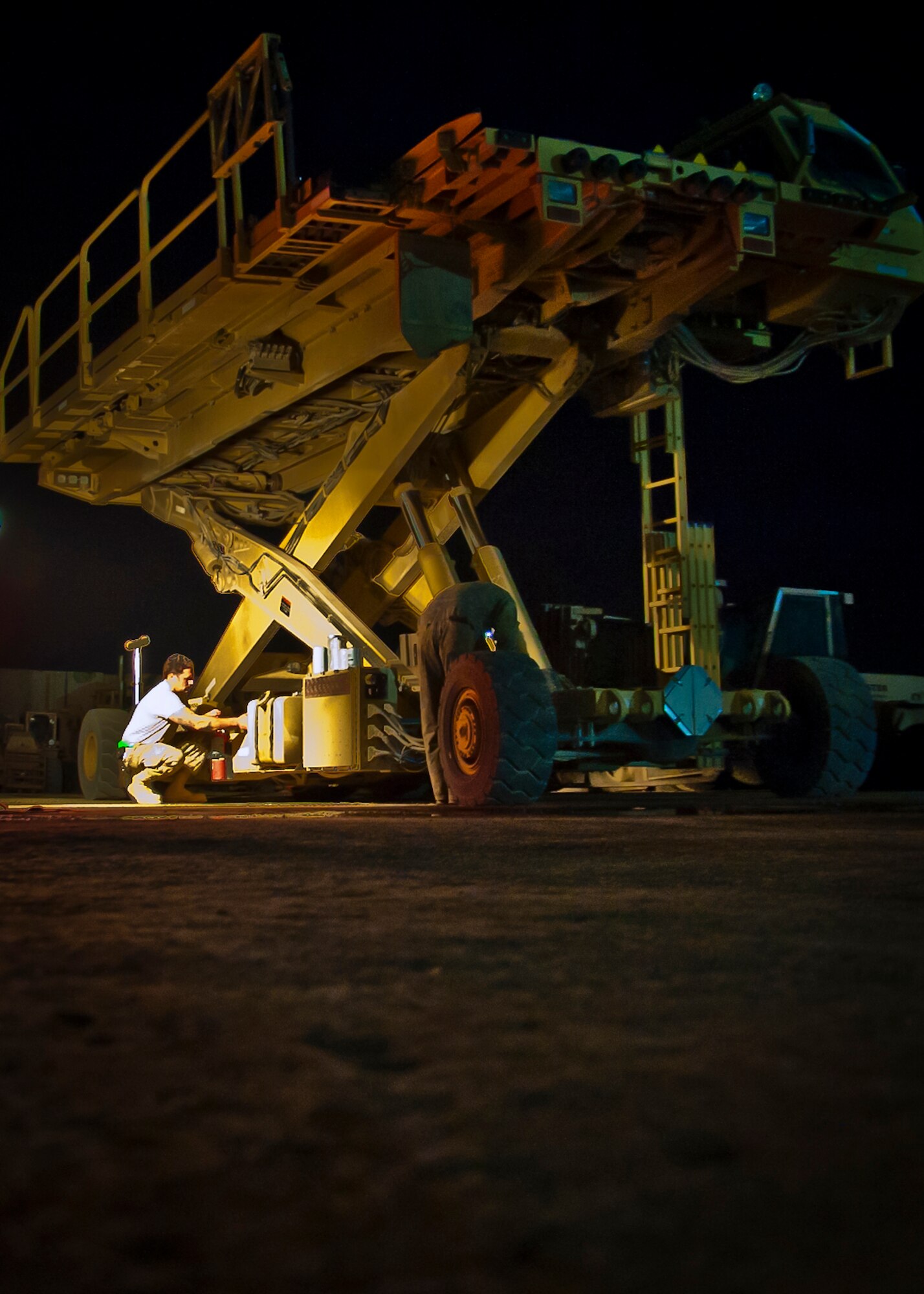 U.S. Air Force Tech. Sgt. Cole Seal, 451st Expeditionary Logistics Readiness Squadron, works on a Halvorsen 25K aircraft cargo loader at Kandahar Airfield, Afghanistan, May 29, 2013. The maintenance work enables aerial porters to continue loading and unloading cargo from military and commercial aircraft with the Halvorsen Loader. Seal is deployed here from the 436th Logistics Readiness Squadron at Dover Air Force Base, Del. (U.S. Air Force photo/Senior Airman Scott Saldukas)