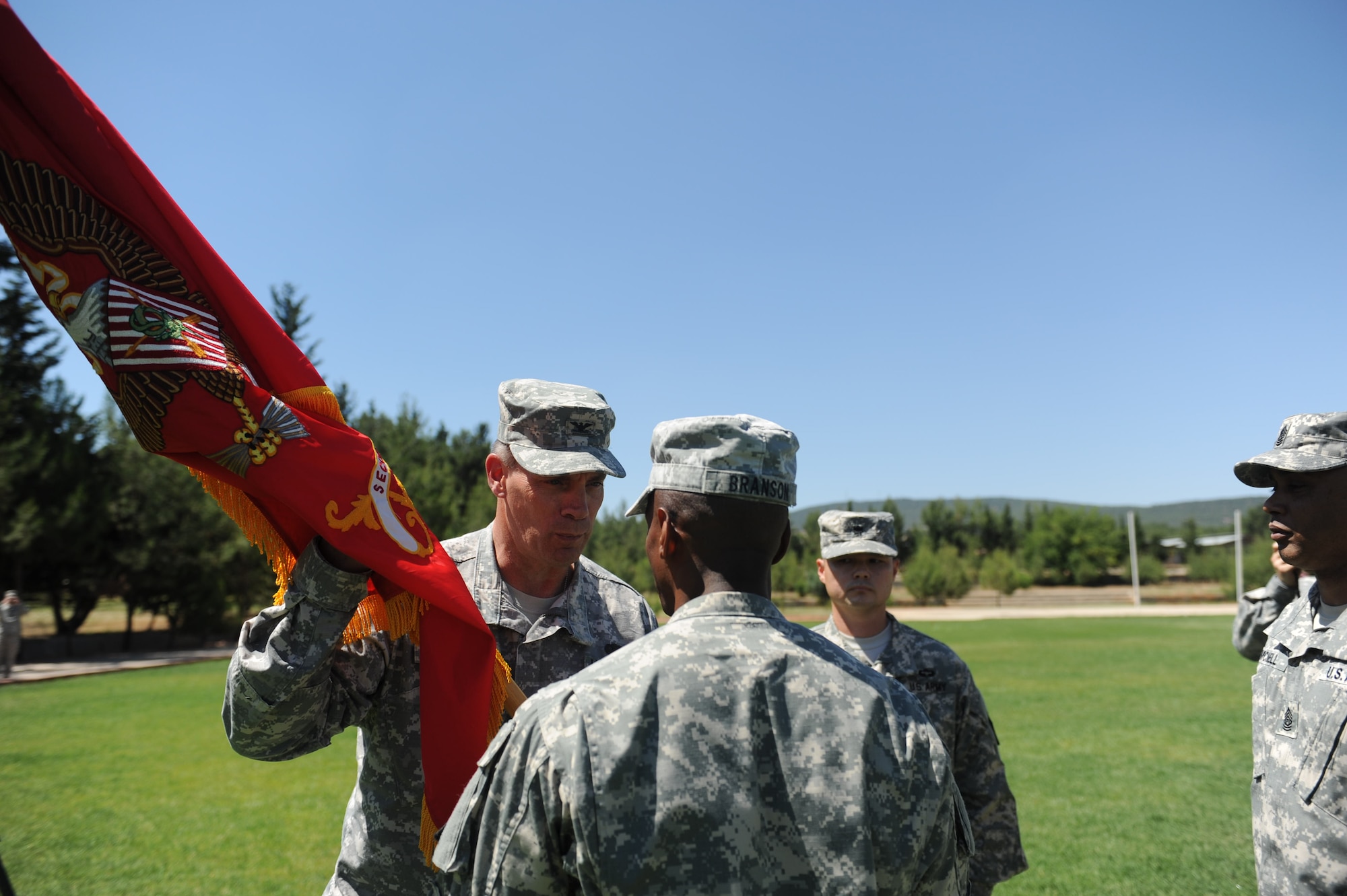 Lt. Col. Charles Branson, outgoing 3rd Battalion, 2nd Brigade Air Defense Artillery commander, front, passes the guidon to Col. Stephen Richmond, 10th Army Air and Missile Defense Command commander, during the 3-2 ADA change of command ceremony June 14, 2013, at Gaziantep, Turkey. The change of command ceremony is a tradition that represents a formal transfer of authority and responsibility from the outgoing commander to the incoming one. (U.S. Air Force photo by Senior Airman Daniel Phelps/Released)