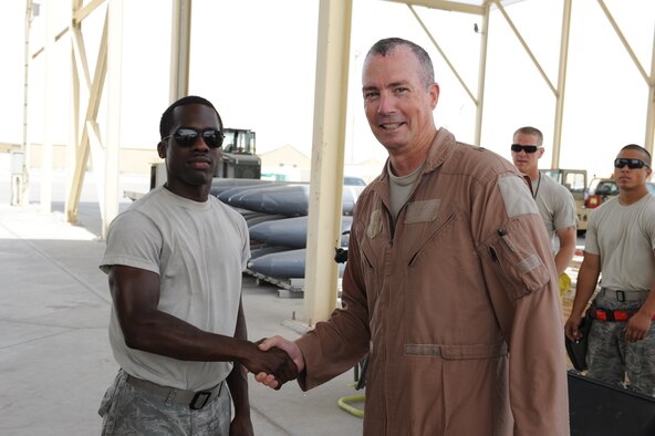 Brig. Gen. Paul McGillicuddy, 380th Air Expeditionary Wing commander, right, thanks Senior Airman Denarius Pittman, 380th Expeditionary Aircraft Maintenance Squadron assistant-dedicated crew chief, for making his final flight was successful at an undisclosed location in Southwest Asia June 12, 2013.
