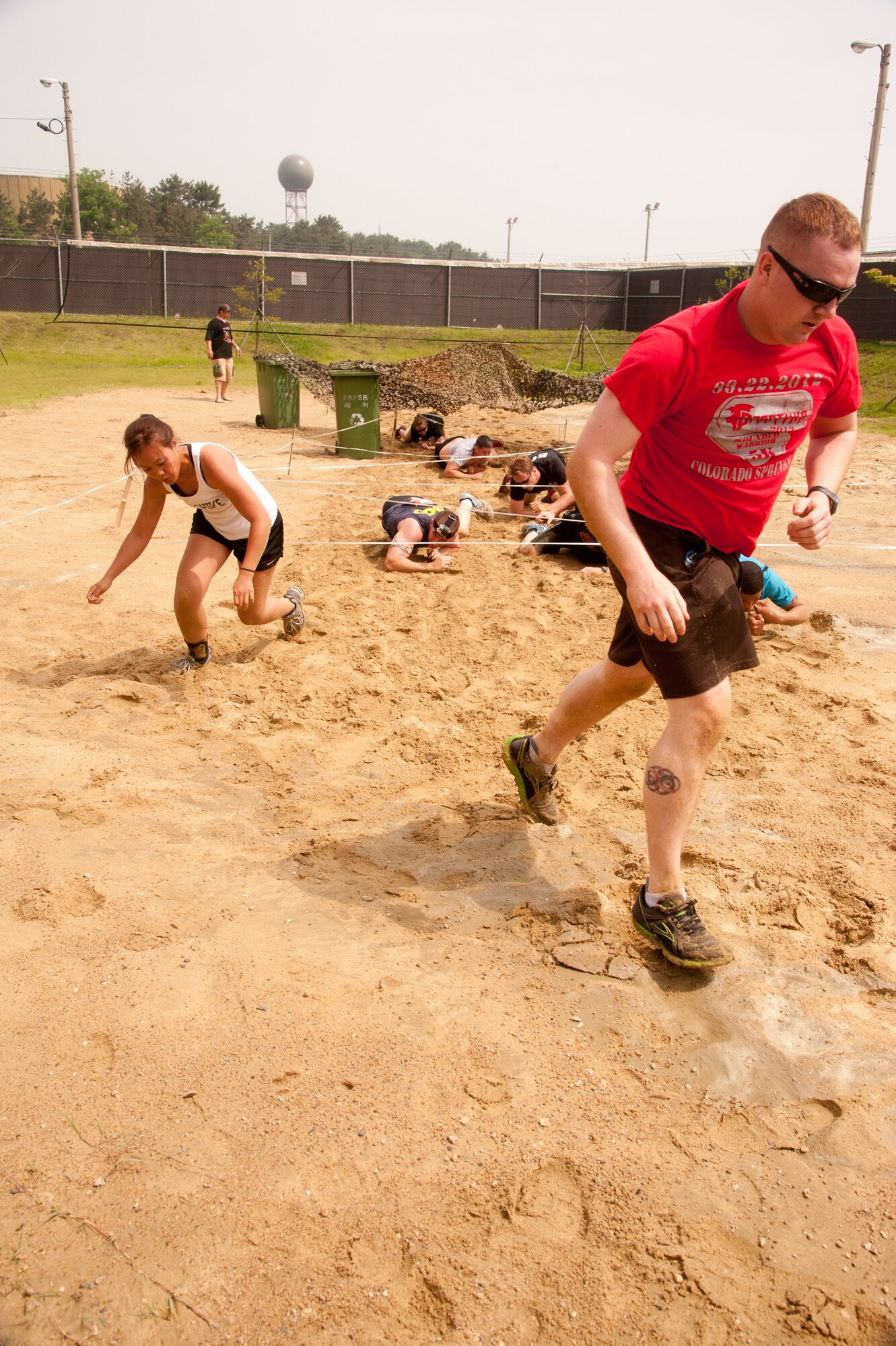 Team members of the 8th Maintenance Squadron complete the third obstacle of the Wolf Pack Warrior Mud Run at Kunsan Air Base, Republic of Korea, June 8, 2013. All the teams demonstrated the wingman concept throughout the course by ensuring every team member finished before moving to the next station. (U.S. Air Force photo by Senior Airman Jessica Haas/ Released)