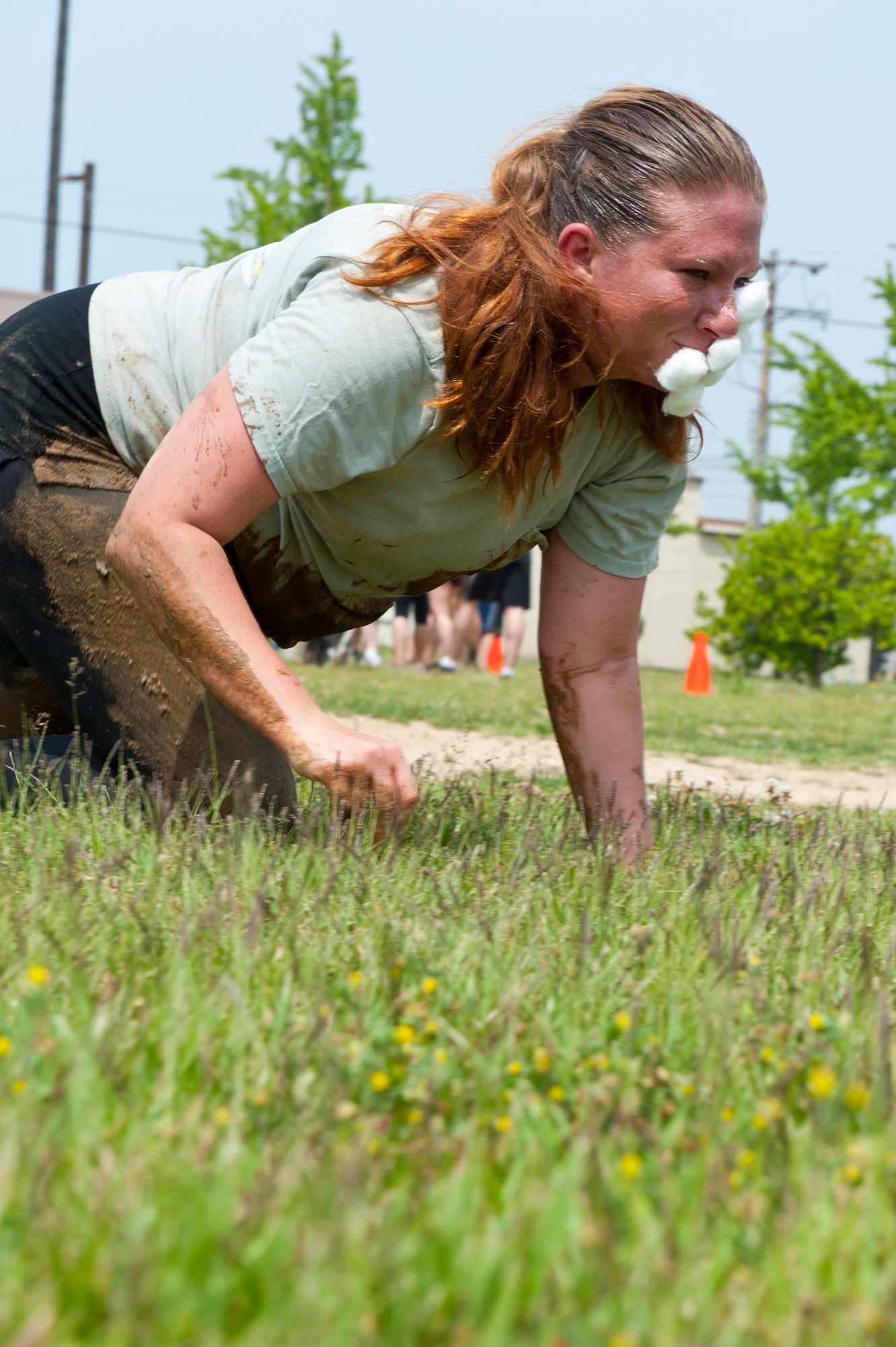 Staff Sgt. Kristie Stefinsky, 8th Force Support Squadron, high crawls with cotton balls stuck to her nose during the Wolf Pack Warrior Mud Run at Kunsan Air Base, Republic of Korea, June 8, 2013. Stefinisky and the rest of her four-member team were required to collect a total of four cotton balls using Vaseline put on their noses. (U.S. Air Force photo by Staff Sgt. Jonathan Fowler/Released)