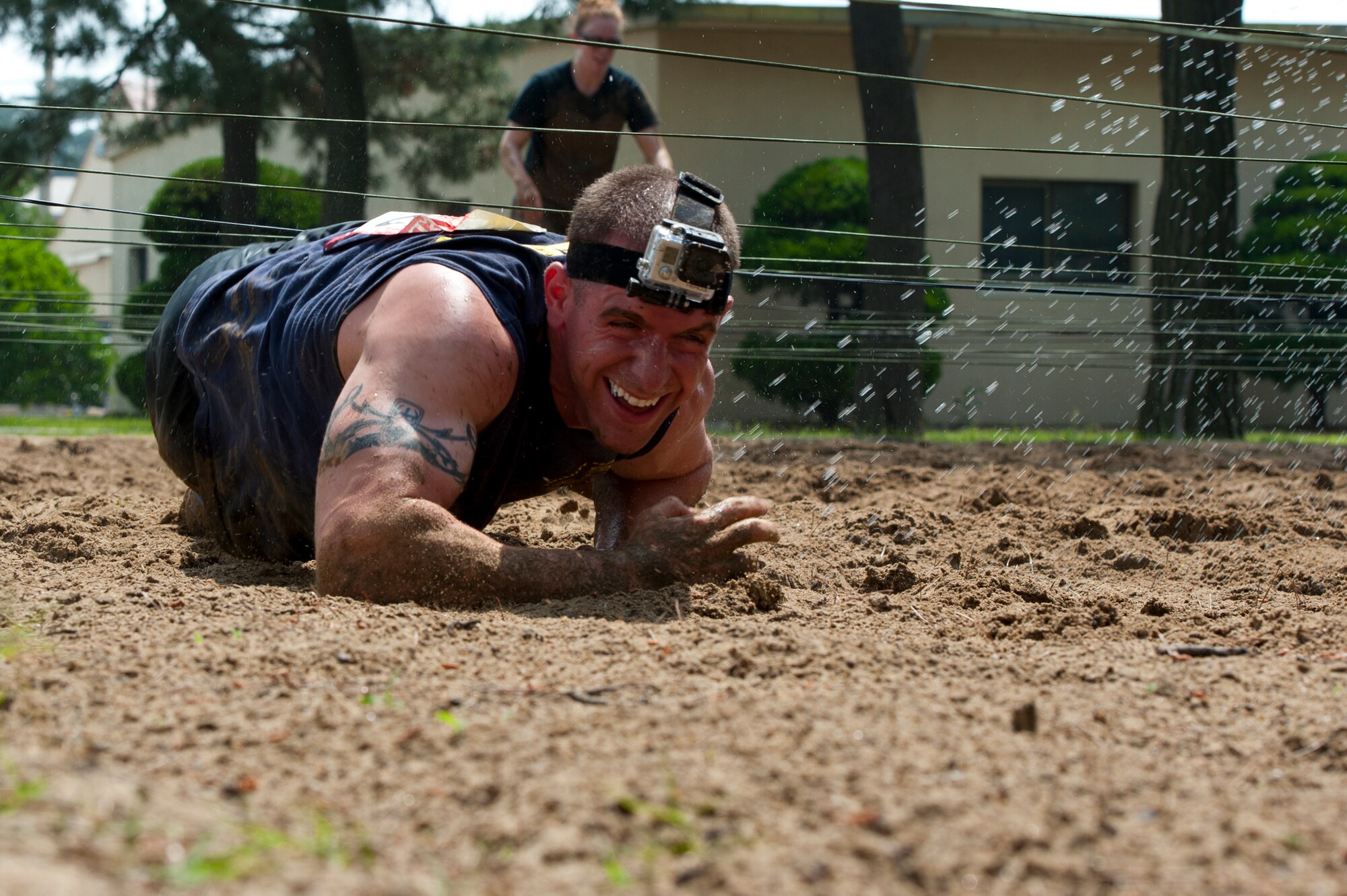 Tech. Sgt. Ryan Bobzin, 8th Civil Engineer Squadron explosive ordnance disposal technician, low crawls through the mud at Kunsan Air Base, Republic of Korea, June 8, 2013. More than 35 teams of four members participated in the Warrior Mud Run which honored  1st Lt. Josh Hovies, who passed in April 2013. (U.S. Air Force photo by Staff Sgt. Jonathan Fowler/Released)