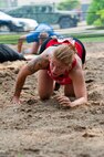 Staff Sgt. Angela Hicks, 8th Medical Support Squadron, low crawls through the mud at Kunsan Air Base, Republic of Korea, June 8, 2013. This was part of the Wolf Pack’s first Warrior Mud Run, which honored 1st Lt. Josh Hovies, who was organizing the event for charity before he passed in April 2013. (U.S. Air Force photo by Staff Sgt. Jonathan Fowler/Released)