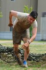 Capt. Reza Rahimi, 8th Fighter Wing executive officer, scrambles to the next obstacle after low crawling through mud during the Wolf Pack Warrior Mud Run at Kunsan Air Base, Republic of Korea, June 8, 2013. The run featured nine obstacles and challenges for participants to tackle. (U.S. Air Force photo by Staff Sgt. Jonathan Fowler/Released)