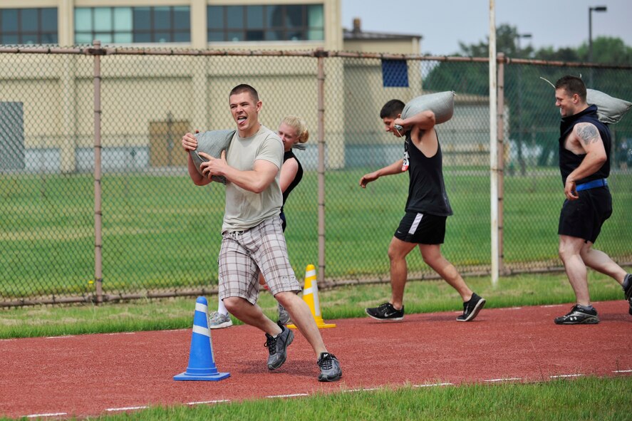 A team  weaves through an obstacle carrying sand bags during the Wolf Pack Warrior Mud Run at Kunsan Air Base, Republic of Korea, June 8, 2013. More than 140 Airmen participated in the event which raised more than $2,600 for the Special Operations Warrior Foundation. (U.S. Air Force photo by Senior Airman Clayton Lenhardt/Released)
