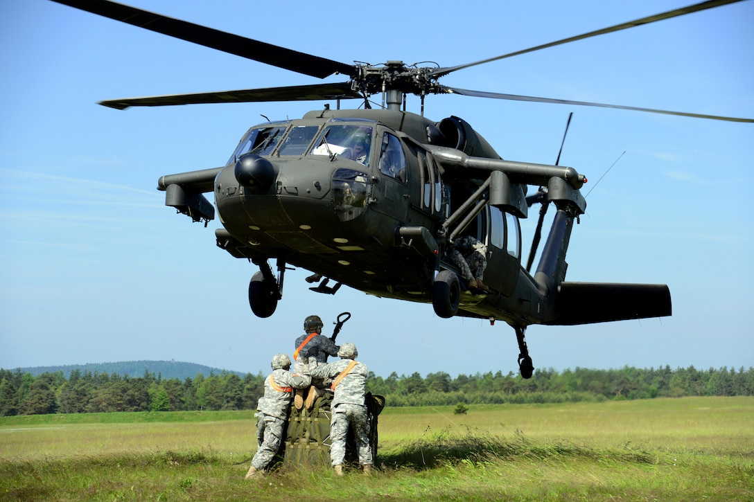U.S. soldiers attach the hook to a UH-60 Black Hawk helicopter during sling load operations at the Grafenwoehr Training Area, Germany, June 13, 2013. Helicopter sling load operations are the key to moving supplies and equipment to remote locations.