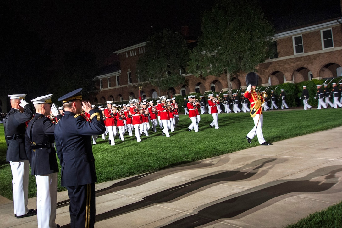 Marine Corps Col. Christian Cabaniss, left, Marine Corps Commandant Gen. James F. Amos, center, and Army Gen. Martin E. Dempsey, chairman of the Joint Chiefs of Staff, render honors during the Marine Corps evening parade at the Marine Barracks in Washington D.C., June 14, 2013.