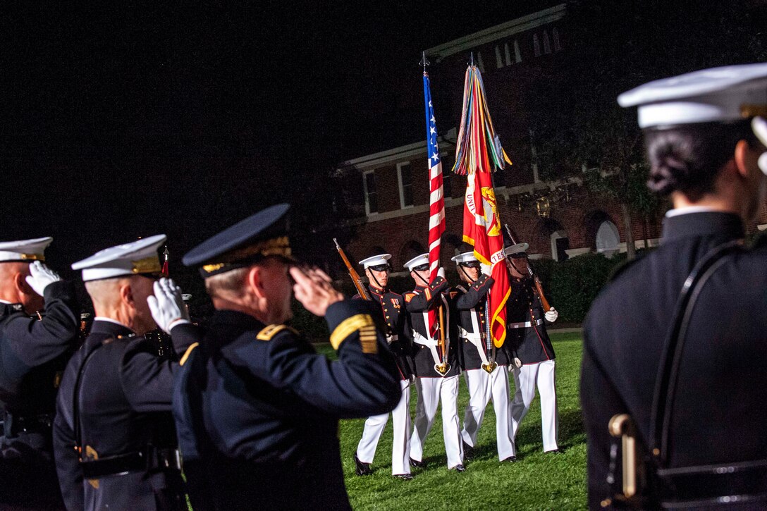 Marine Corps Col. Christian Cabaniss, left, Marine Corps Commandant Gen. James F. Amos, center, and Army Gen. Martin E. Dempsey, chairman of the Joint Chiefs of Staff, render honors to the colors during the evening parade at the Marine Barracks in Washington D.C., June 14, 2013.