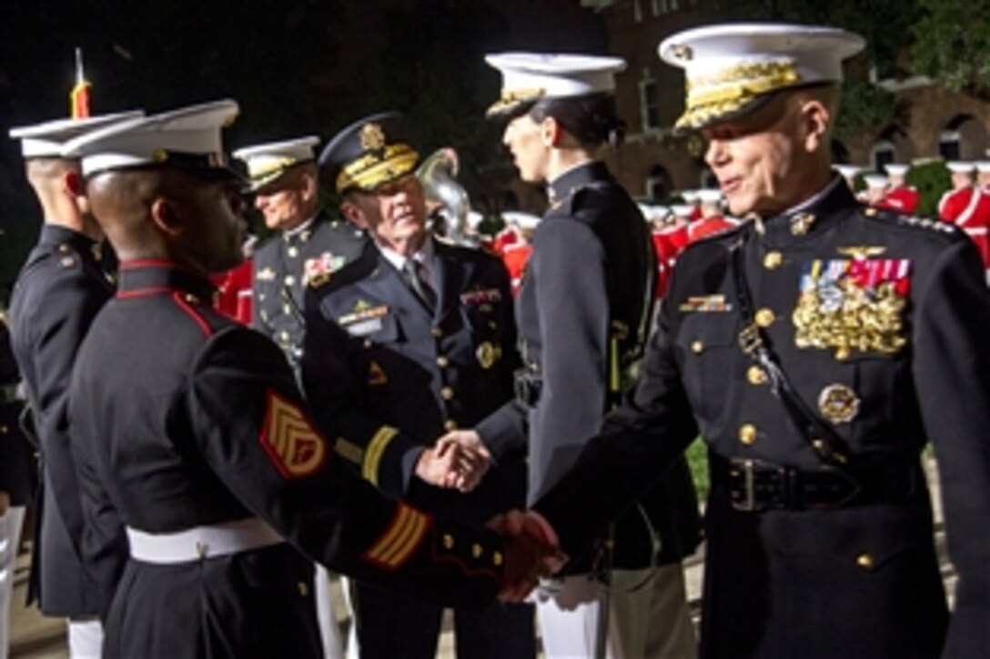 Army Gen. Martin E. Dempsey, center, chairman of the Joint Chiefs of Staff, Marine Corps Commandant Gen. James F. Amos, far right, and Marine Corps Sgt. Maj. Bryan B. Battaglia, back left, the chairman's senior enlisted advisor, greet Marines during the Marine Corps evening parade at the Marine Barracks in Washington, D.C., June 14, 2013.