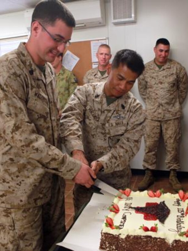Seaman Chris Walerysiak (left), corpsman, Lima Company, 3rd Battalion, 3rd Marine Regiment, Marine Rotational Force – Darwin, and Chief Petty Officer Eduardo Magpayo (right), senior medical representative, Lima Co., 3rd Bn., 3rd Marine Regiment, MRF-D, cut the first piece of cake during the cake cutting ceremony at a US Navy Hospital Corps birthday celebration, here, June 17. This birthday marks 115 years of the US Navy Hospital Corps.

