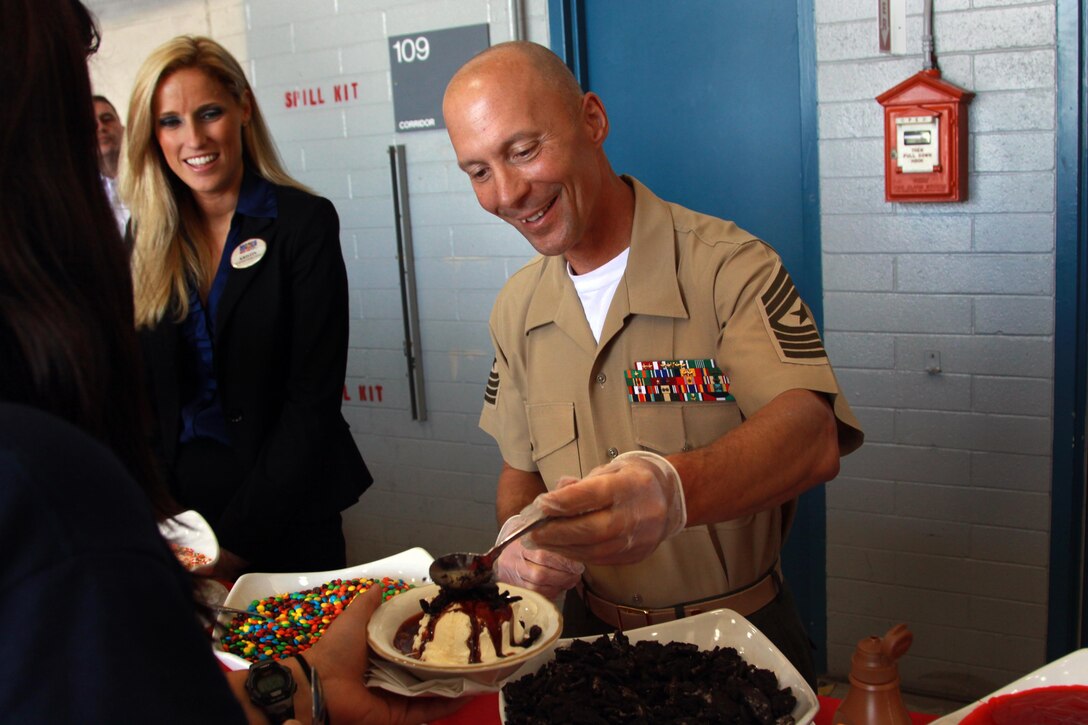 Sgt. Maj. Scott R. Helms pours crumbled cookies on top of ice cream for the children and mentors of the Tragedy Assistance Program for Survivors at the air station here during their four-day Good Grief Camp here, June 14. The children and mentors also enjoyed pizza and a visit from United States Vice President Joe Biden and his family. Helms is the senior enlisted leader for Camp Pendleton in addition to his regional responsibilities for five Marine Corps installations in the southwestern United States.