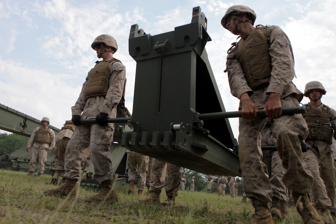 BATTLE CREEK, Mich. – Marines with 6th Engineer Support Battalion use a team-lift technique to move a 300 pound piece of bridge equipment during a training exercise here, June 11. Many of the pieces used to put together a medium girder bridge require more than one Marine to effectively move them. 