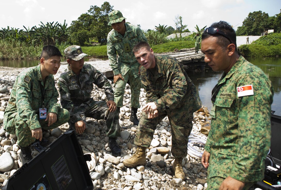 U.S. Marine Sgt. Robert Walker (second from right), an electrical equipment repair specialist with III Marine Expeditionary Force, demonstrates the capabilities of the a Solar Hybrid Expeditionary Power and Purification Systems to purify the water as part of a disaster-response scenario during the ASEAN Humanitarian Assistance/Disaster Relief and Military Medicine Exercise hosted by Brunei Darussalam June 17 in Temburong, Brunei. The ASEAN exercise marks the first time multinational forces will conduct a field training exercise under the ASEAN Defence Ministers Meeting-Plus architecture and is a milestone event for regional cooperation. More than 2,500 multinational personnel from 18 Asia-Pacific nations are participating in the ASEAN exercise from June 17 to 20.