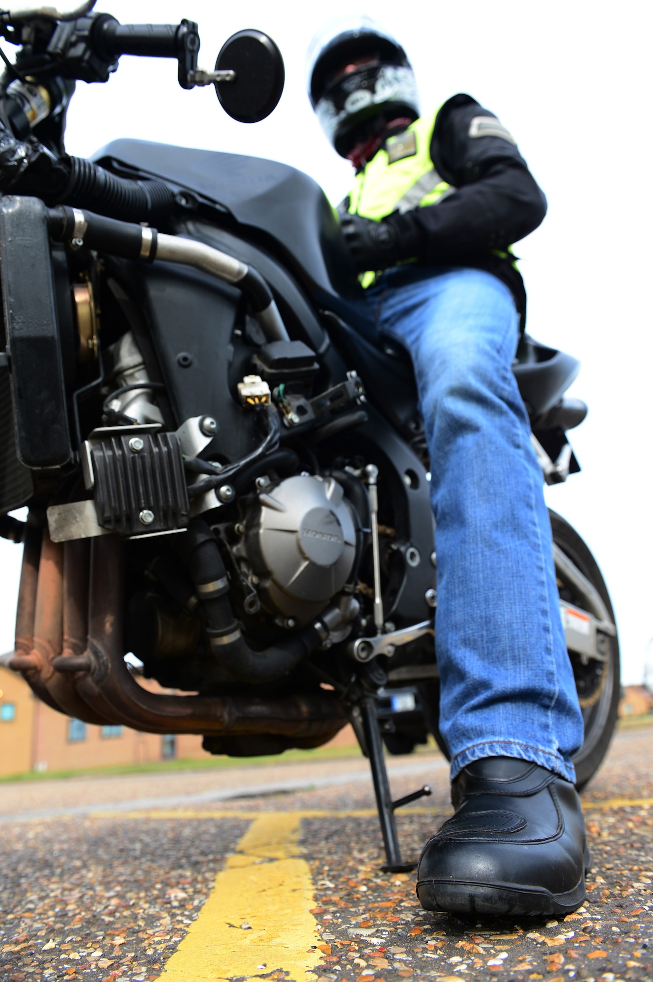 ROYAL AIR FORCE LAKENHEATH - Senior Airman Nikolas Kinder, 48th Equipment Maintenance Squadron phase inspection journeyman, prepares to ride his motorcycle June 17, 2013. Airmen who ride motorcycles are required to wear an approved helmet; a long-sleeved shirt or jacket that is brightly colored, visible and reflective at night; long pants; full-fingered gloves; sturdy footwear and eye protection including prescription glasses. For members in England, helmets must meet United Nations Economic Commission for Europe Standard 22.05 or British Standard 6658 and be properly fastened under the chin. (U.S. Air Force photo by Senior Airman Lausanne Morgan)
