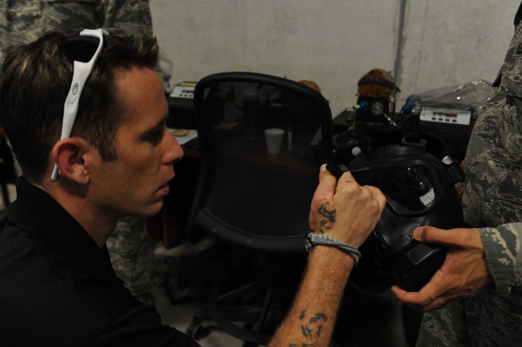 Bryan Anderson, U.S. Army veteran and triple amputee, inspects the drinking tube of a gas mask during his tour of the 18th Logistics Readiness Squadron individual protective equipment element on Kadena Air Base, Japan, June 17, 2013. Anderson was surprised to see the changes that have been made to the gas mask since he left the service. (U.S. Air Force photo by Airman 1st Class Malia Jenkins/Released)