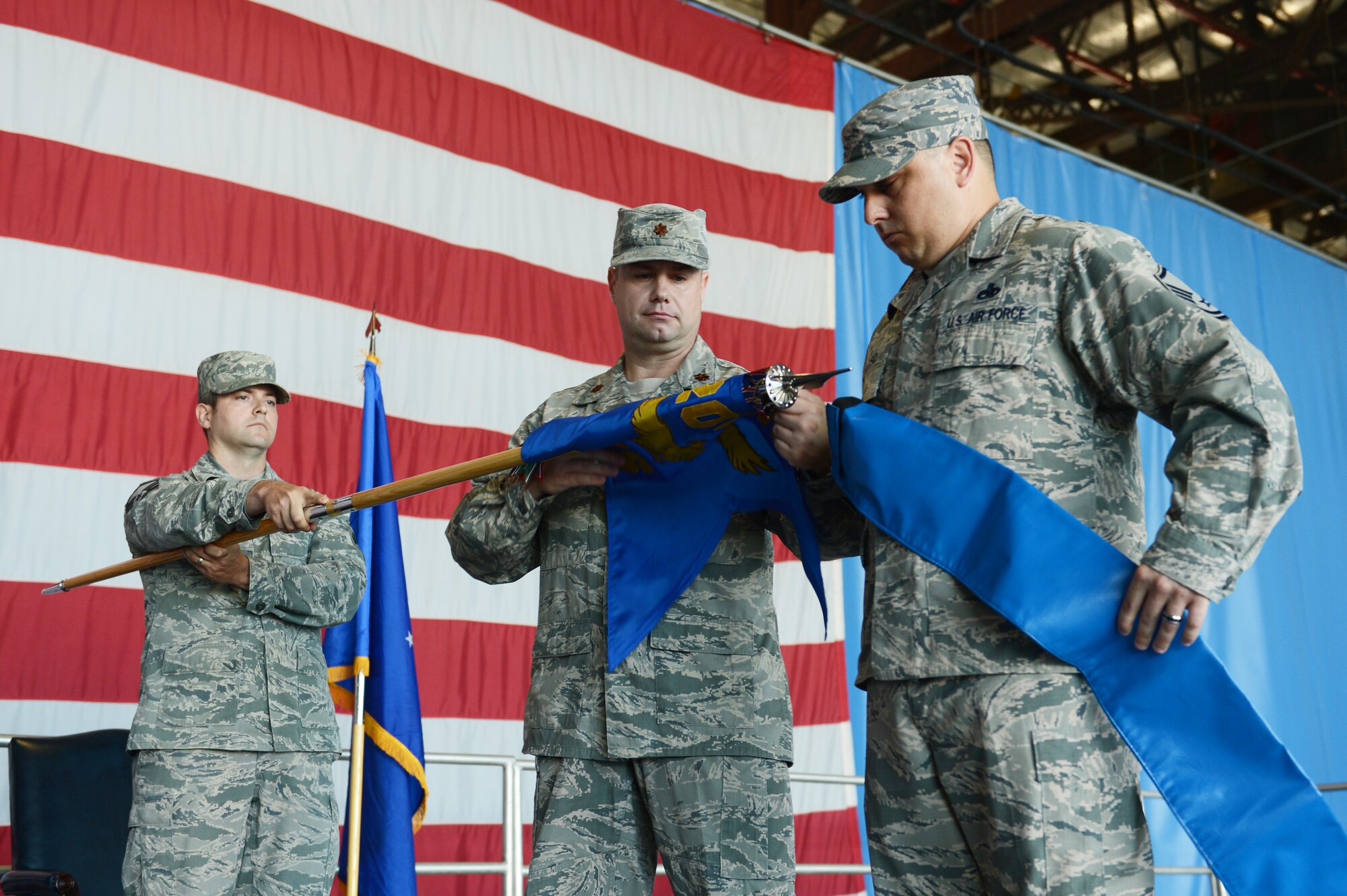 U.S. Air Force Maj. Michael Fields, 20th Maintenance Operations Squadron commander, rolls up the squadron’s colors during the inactivation ceremony of 20th MOS at Shaw Air Force Base, S.C., June 14, 2013. The colors of an inactivated squadron are stored at Wright Patterson Air Force Base Museum, Ohio, until the squadron is reactivated at a future date. (U.S. Air Force photo by Airman 1st Class Krystal M. Jeffers/ Released)