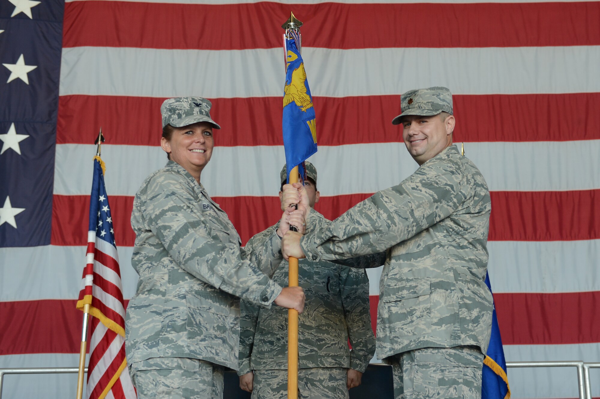 U.S. Air Force Col. Helen Brasher, 20th Maintenance Group commander, accepts the 20th Maintenance Operations Squadron’s guidon from Maj. Michael Fields, 20th MOS commander, during the inactivation ceremony of 20th MOS at Shaw Air Force Base, S.C., June 14, 2013. The 20th MOS will still perform their daily duties but they will be assigned under the 20th MXG. (U.S. Air Force photo by Airman 1st Class Krystal M. Jeffers/ Released)