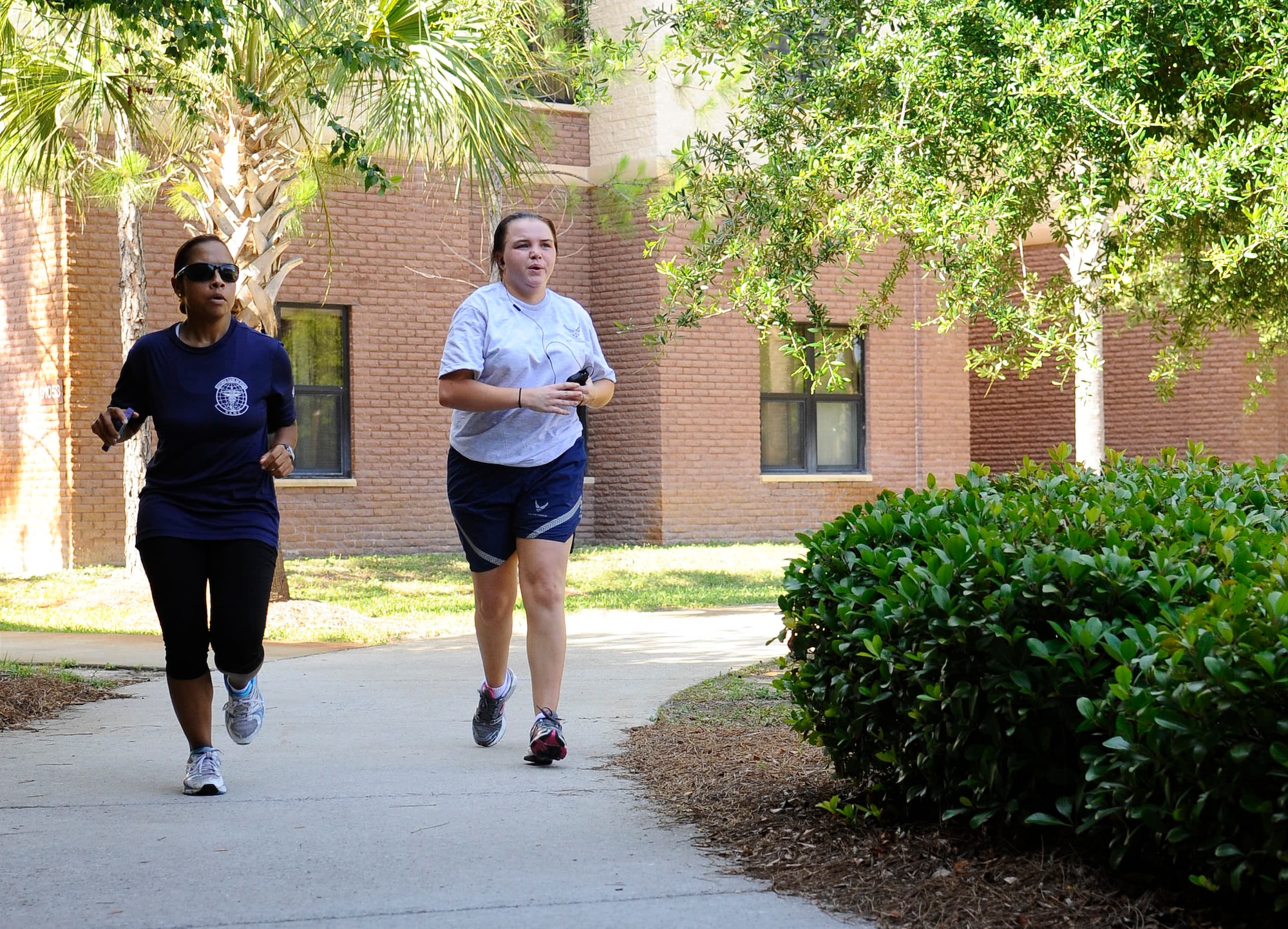 April Royster, Health and Wellness Center health and fitness specialist, left, helps Senior Airman Chelsea Bolding, 1st Special Operations Dental Squadron dental laboratory technician, keep pace during a mile-and-a-half run outside the Riptide Fitness Center on Hurlburt Field, Fla., June 17, 2013. “My goal is to train each individual on how to progressively increase their physical training after pregnancy and prepare them for their upcoming fitness assessment test which is due 180 days after delivery,” Royster said. (U.S. Air Force photo by Airman 1st Class Jeffrey Parkinson)

