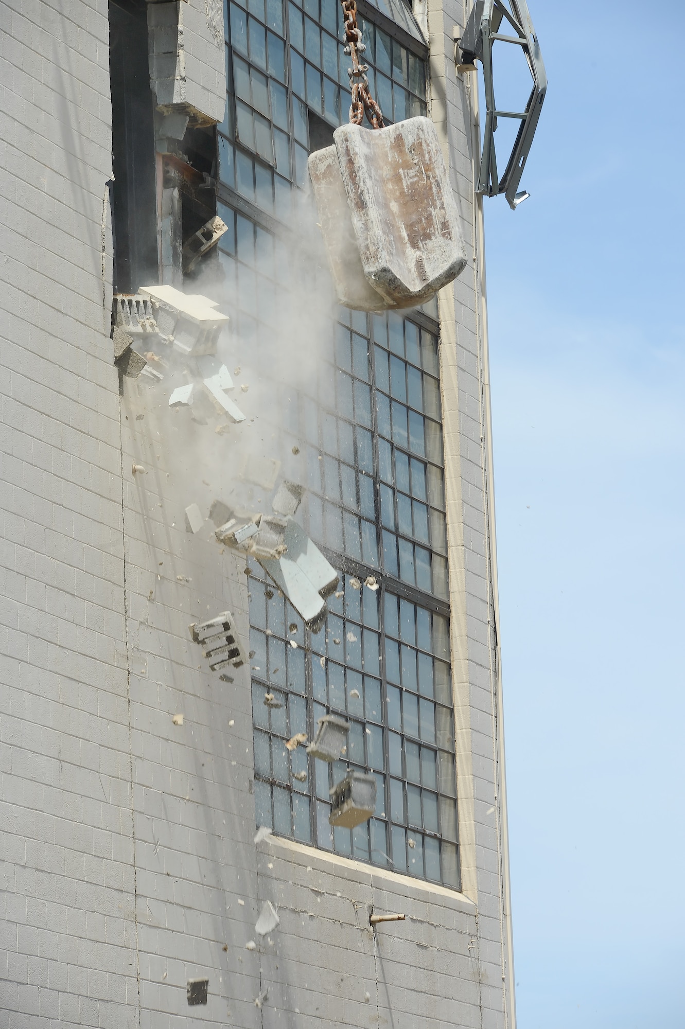 Part of a cinderblock wall crashes down after being struck by a 5-ton steel cutting ball during the demolition of building 617 on June 5, 2013, at Dover Air Force Base, Del. The plant was replaced with a natural gas heating system that provides hot water and heat for the base.  (U.S. Air Force photo/Greg L. Davis)