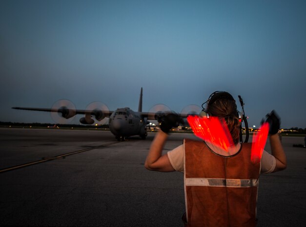 Tech. Sgt. Jessica Strumbly, 910th Airlift Wing C-130 Hercules crew chief, marshals a C-130 into place at Joint Base Charleston – Air Base, S.C., after the unit sprayed for mosquitos June 15, 2013, over JB Charleston – Weapons Station. The insecticide the unit uses is mixed with water to dilute the product. (U.S. Air Force photo/Senior Airman Dennis Sloan)