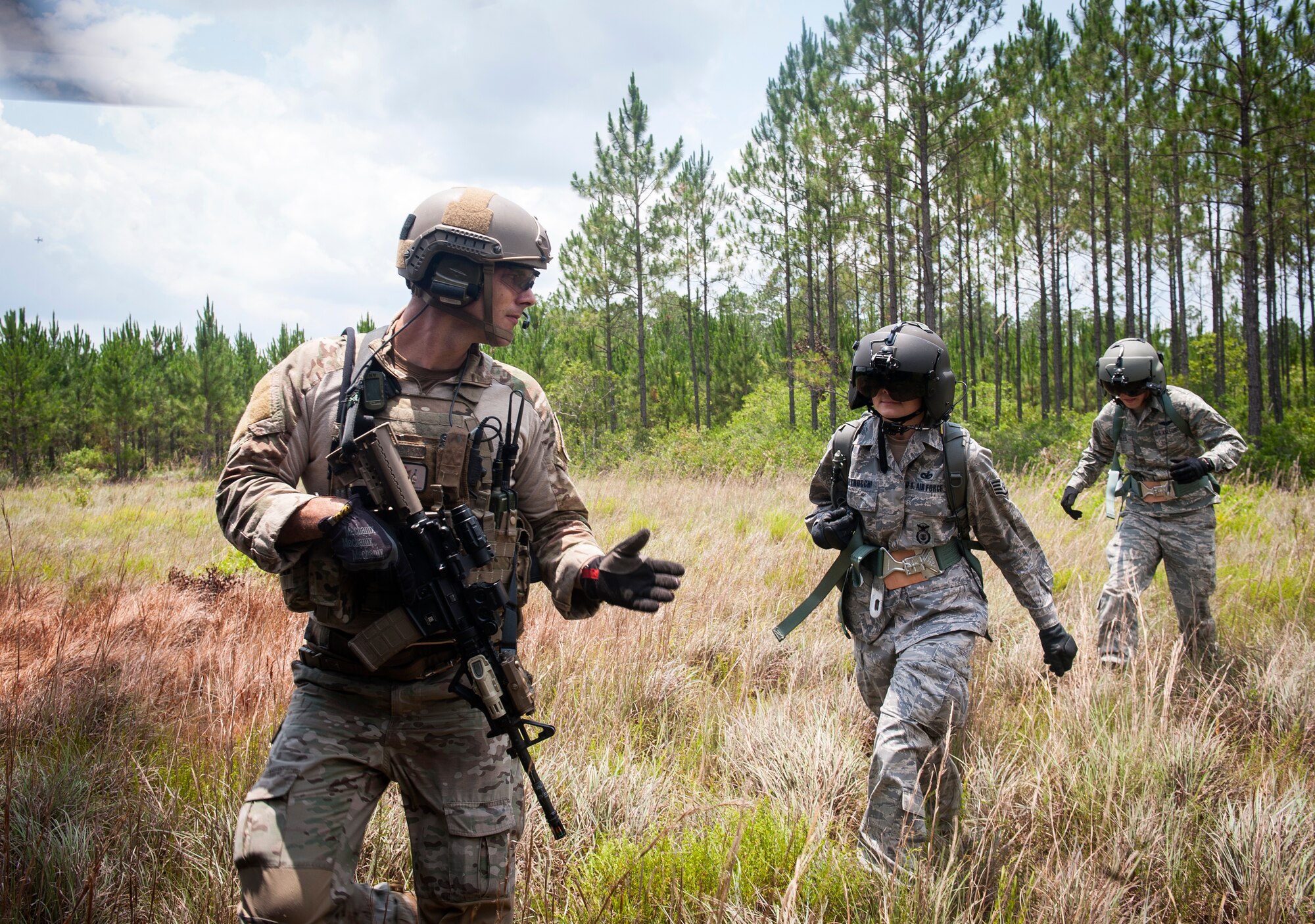 U.S. Air Force Staff Sgt. William Blakeney, 38th Rescue Squadron pararescueman, escorts simulated downed aircrew during 23d Wing Commander Col. Billy D. Thompson’s final flight at Moody Air Force Base, Ga., June 14, 2013. The scenario required the pilot to land in a small opening while the pararescuemen retrieved stranded personnel and escorted them safely to the helicopter. (U.S. Air Force photo by Senior Airman Jarrod Grammel/Released)

