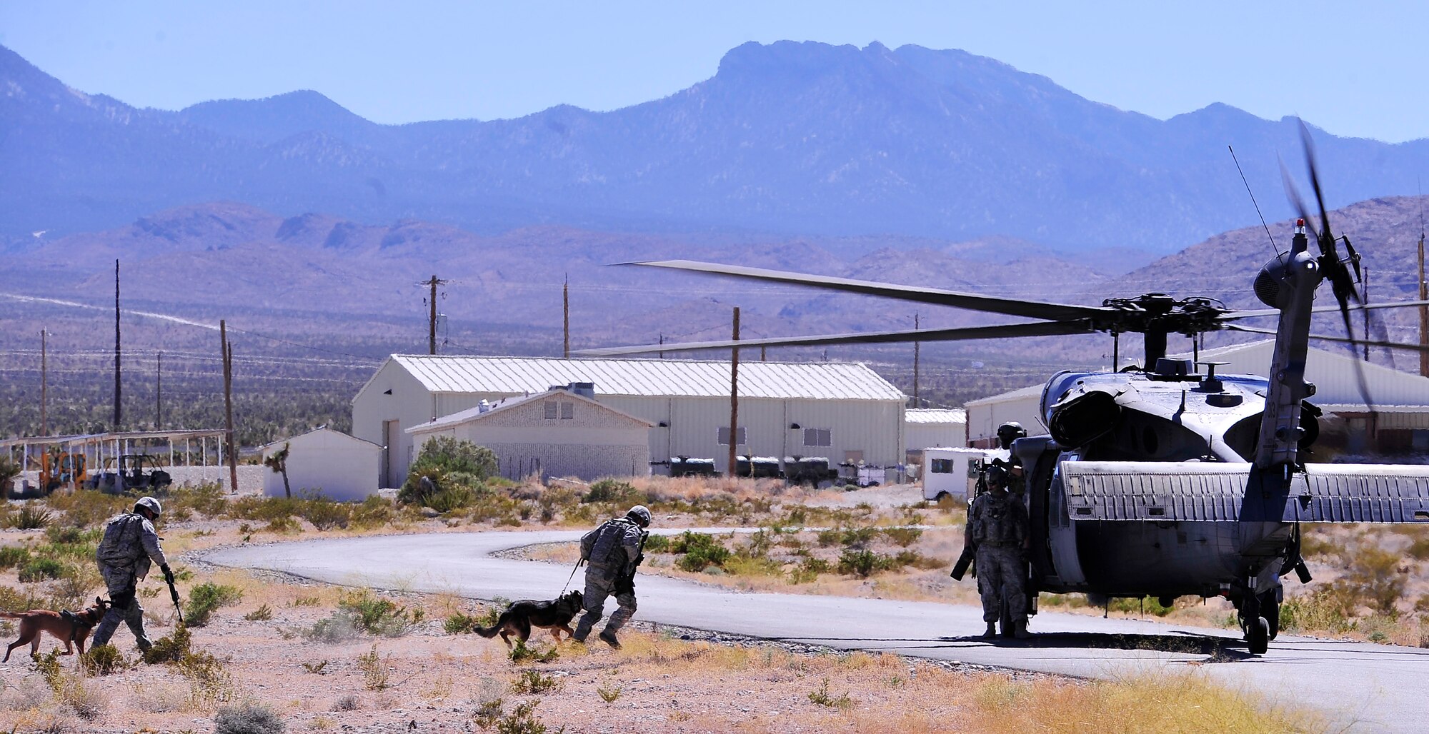 NEVADA TEST AND TRAINING RANGE, Nev. -- Military working dogs and their handlers assigned to the 99th Ground Combat Training Squadron prepare to board and HH-60 Pave Hawk helicopter from the 66th Rescue Squadron outside of Las Vegas June 14, 2013.  The 99th GCTS is the Air Force’s largest regional training center and oversees the pre-deployment training for security forces personnel. (U.S. Air Force photo by Staff Sgt. D.H./Released)