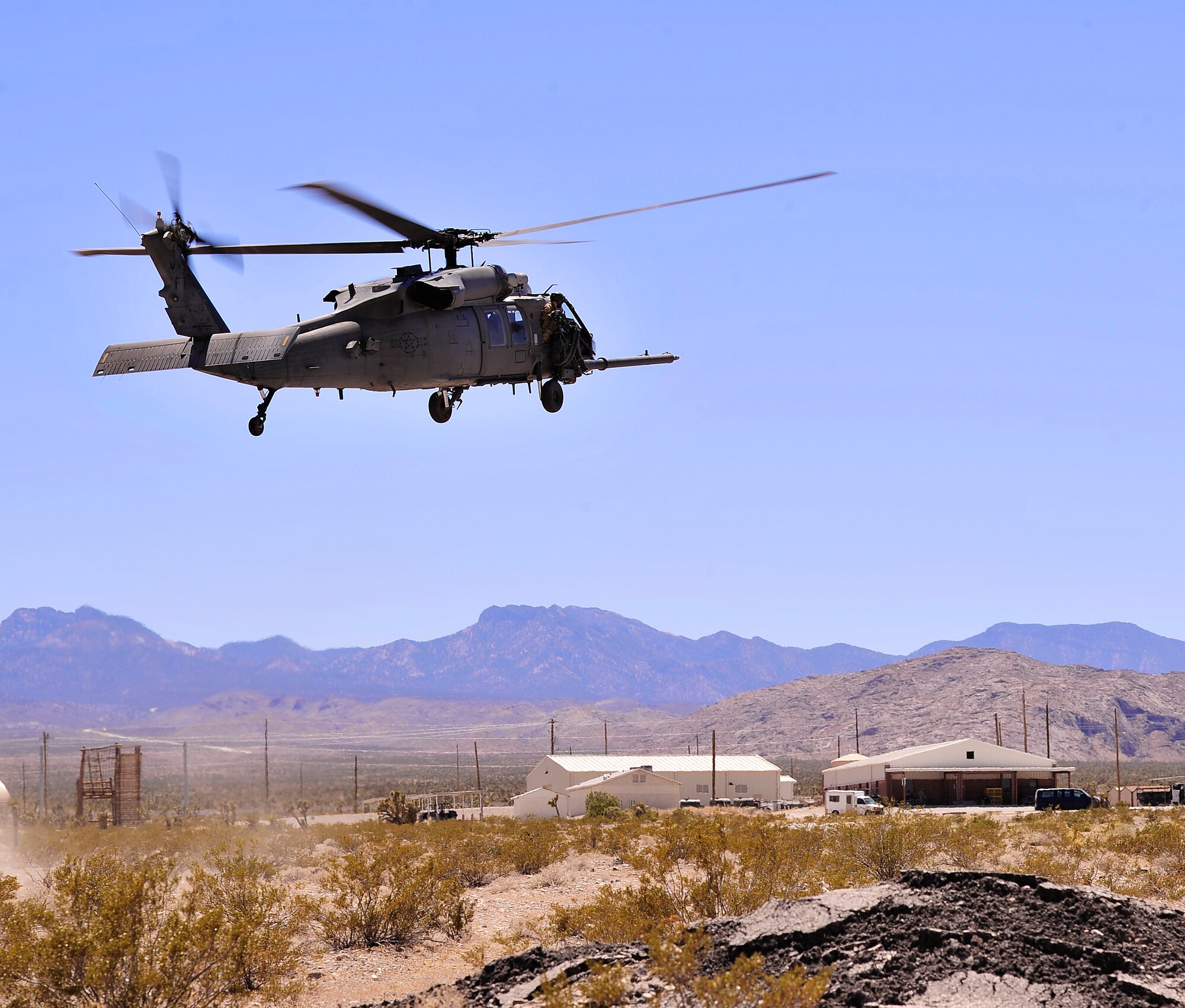 NEVADA TEST AND TRAINING RANGE, Nev. --  An HH-60 Pave Hawk helicopter from the 66th Rescue Squadron at Nellis Air Force Base, carrying security forces members and military working dogs assigned to the 99th Ground Combat Training Squadron prepares to land at a ground combat training range outside of Las Vegas June 14, 2013. The Pave Hawk is a highly modified version of the Army Black Hawk helicopter which features an upgraded communications and navigation suite that enables rescue personnel the ability to conduct day or night personnel recovery operations into hostile environments to recover isolated personnel during war.  (U.S. Air Force photo by Staff Sgt. D.H./Released)