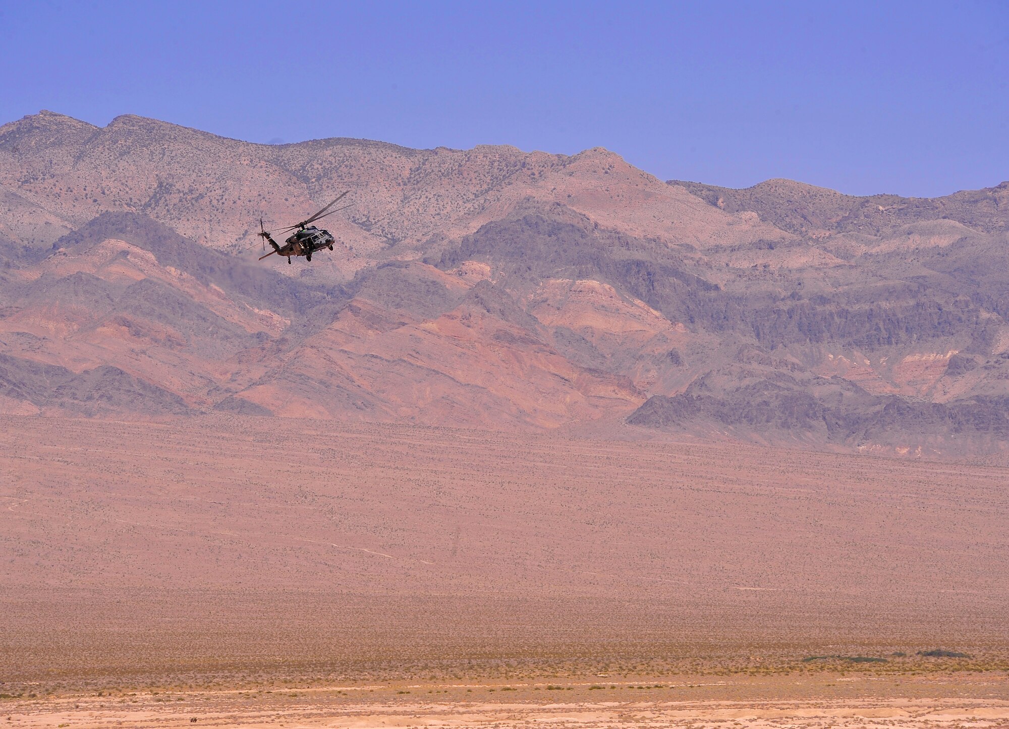 NEVADA TEST AND TRAINING RANGE, Nev. -- An HH-60G Pave Hawk helicopter from the 66th Rescue Squadron at Nellis Air Force Base transports security forces members and military working dogs from the 99th Ground Combat Training Squadron during ground combat training outside of Las Vegas June 14, 2013.  The 66th RQS is one of six active-duty Air Force HH-60 combat rescue units whose mission is to provide world-wide combat rescue and to provide rescue support for air operations over the Nellis Range Complex and backup rescue for civilian agencies in the local area and the greater southwestern United States. (U.S. Air Force photo by Staff Sgt. D.H./Released)