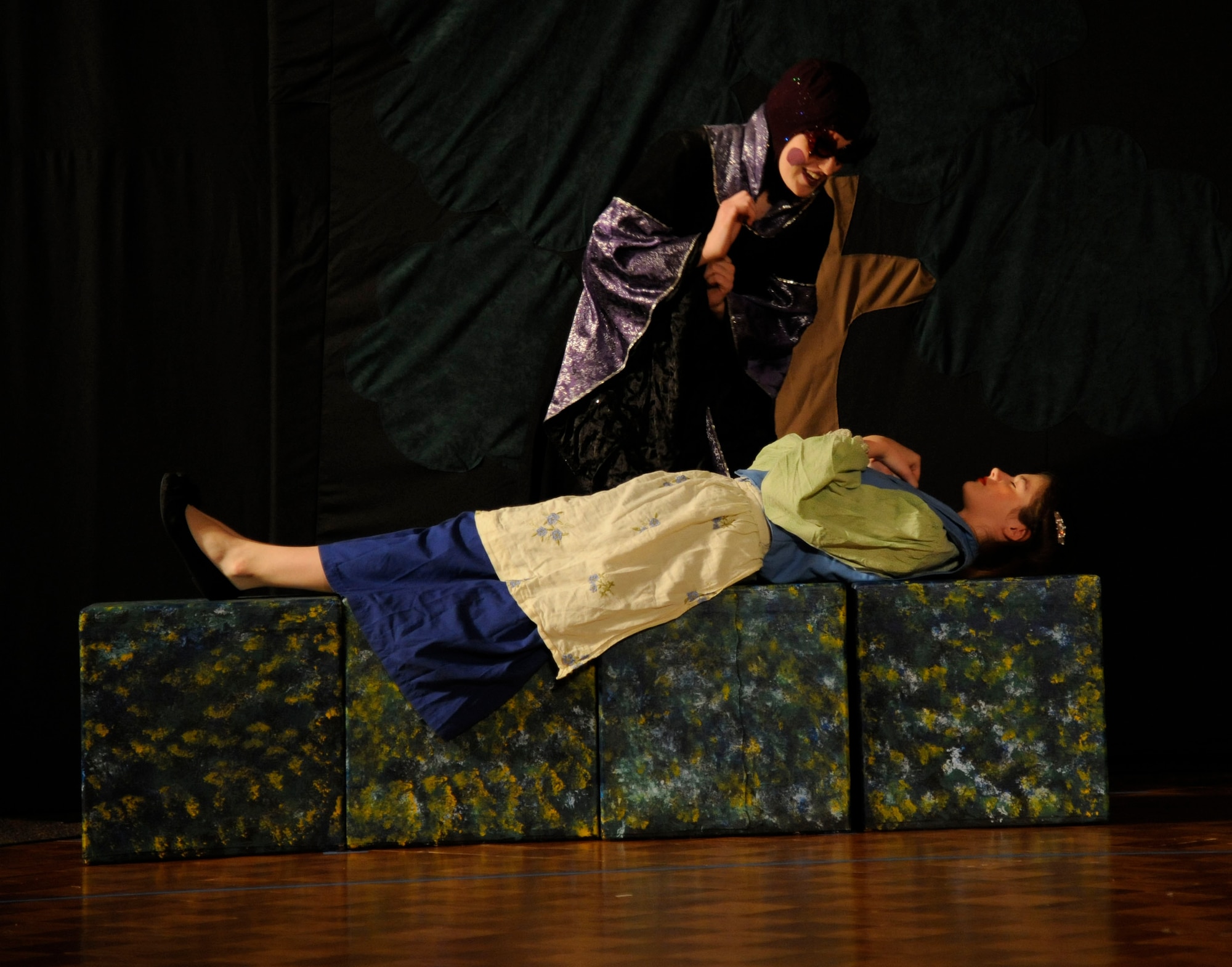 The Queen, portrayed by Carolyn Loertscher, puts Snow White, portrayed by Krista Schneider, under a magic spell on Barksdale Air Force Base, La., June 14, 2013. The tale of "Snow White" involves a princess and her evil stepmother's plan to get rid of her for being fairer than herself. (U.S. Air Force photo/Airman 1st Class Andrew Moua)