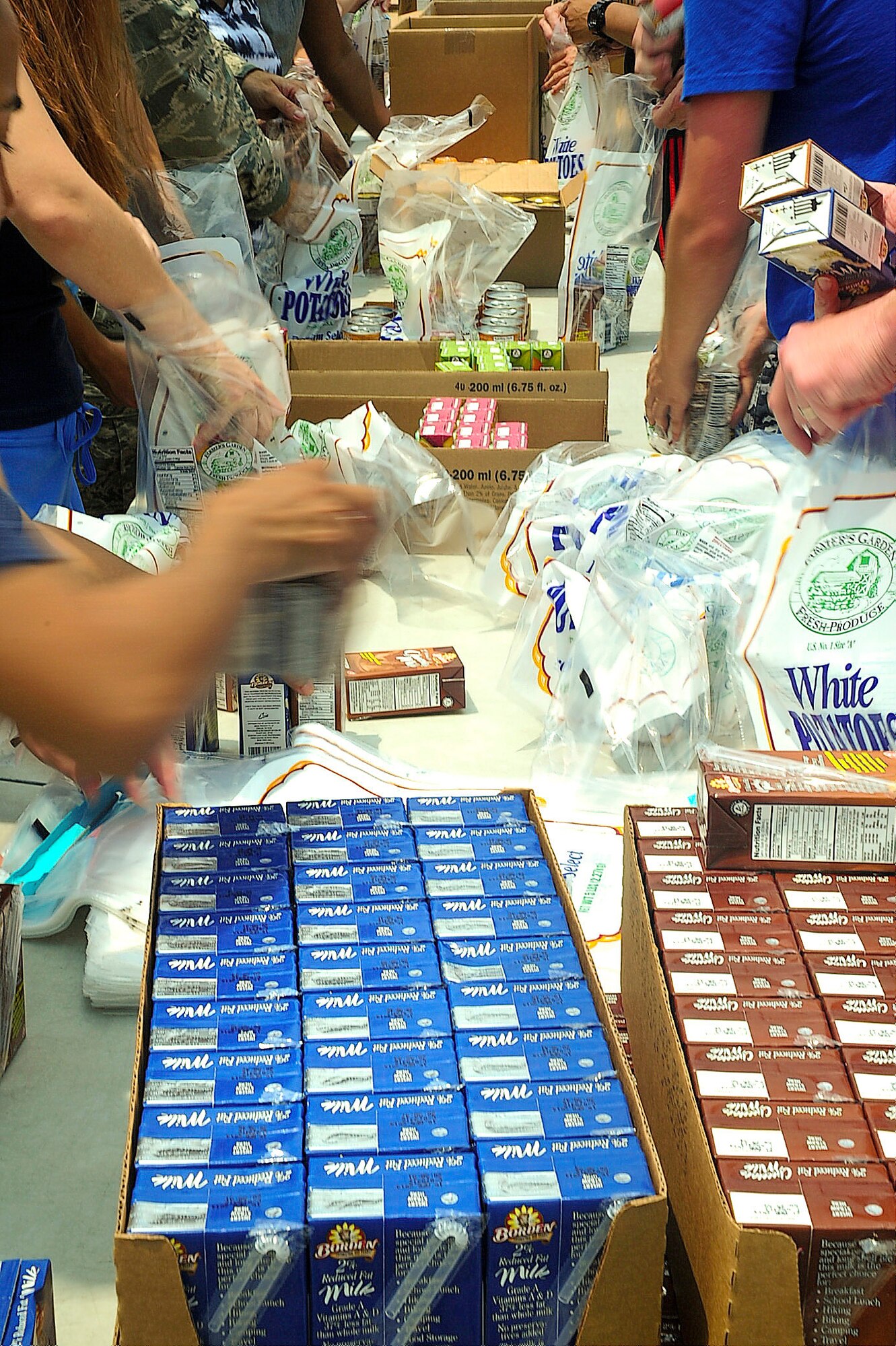 Airmen from Dover Air Force Base, Del., pack meals June 12, 2013, at the Food Bank of Delaware, Milford Branch. Team Dover packed more than 3,000 meals, which were then distributed to underprivileged children. (U.S. Air Force photo/Senior Airman Sam Taylor)
