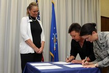 Col. Kathryn Kolbe (right), 75th Air Base Wing commander, signs an official agreement with two of four Utah schools of higher education that are partnering with Hill Air Force Base to provide their library science program students the opportunity to intern at the base's Gerrity Memorial Library. Signing the agreement alongside Kolbe is Wendy Potter, representing Salt Lake Community College. Waiting her turn to sign is Darcy Gregg from Weber State University. (Alex R. Lloyd/U.S. Air Force)