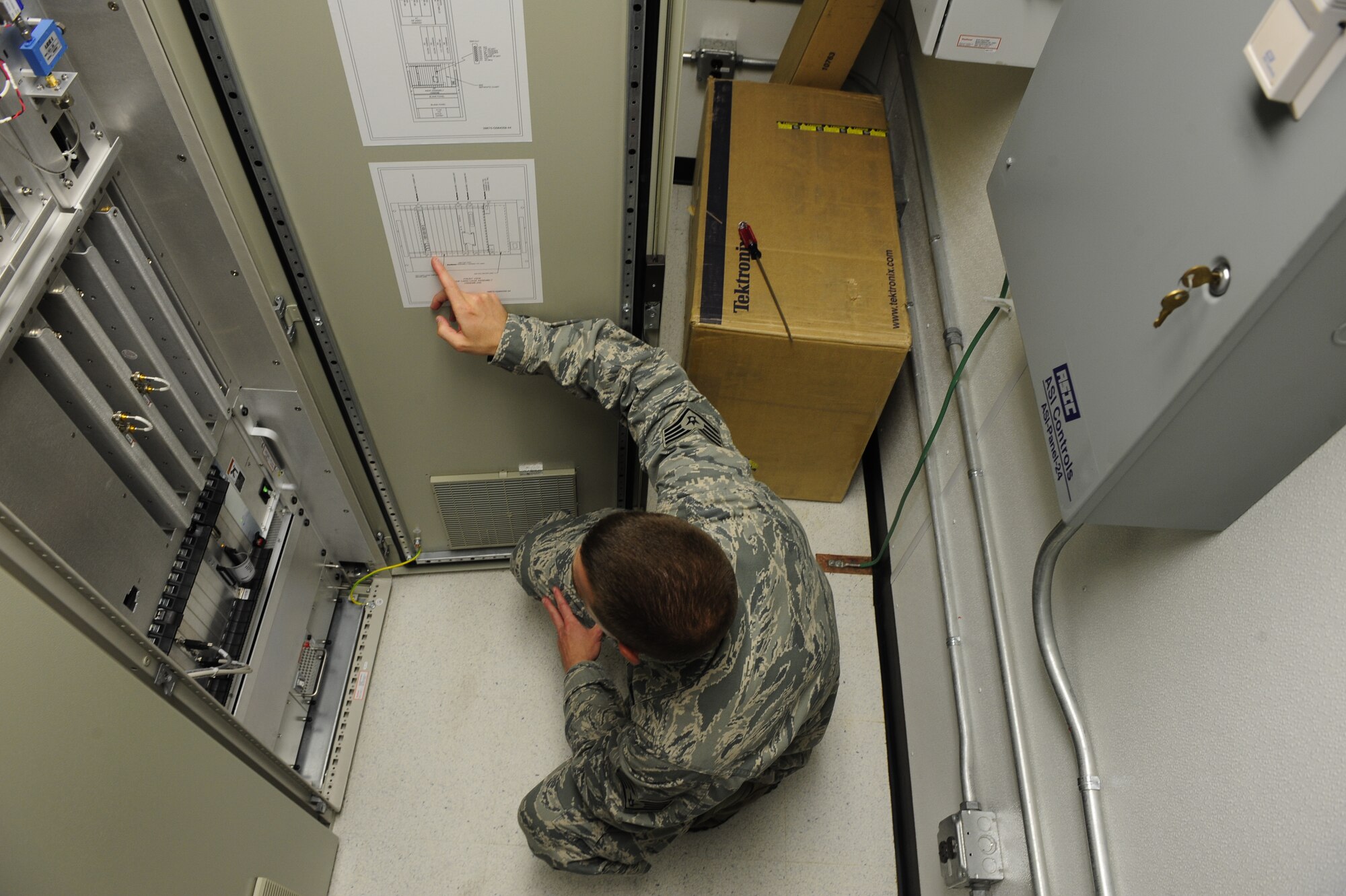 Staff Sgt. Nathan Coley, 20th Communications Squadron ground radar systems supervisor, kneels and checks the Digital Airport Surveillance Radar’s receiver/exciter circuit card assemblies at  Shaw Air Force Base, S.C., June 14, 2013. Coley helps maintain and repair radar surveillance equipment at Shaw so those on the ground can have eyes in the sky. (U.S. Air Force photo by Airman 1st Class Daniel Blackwell/Released)