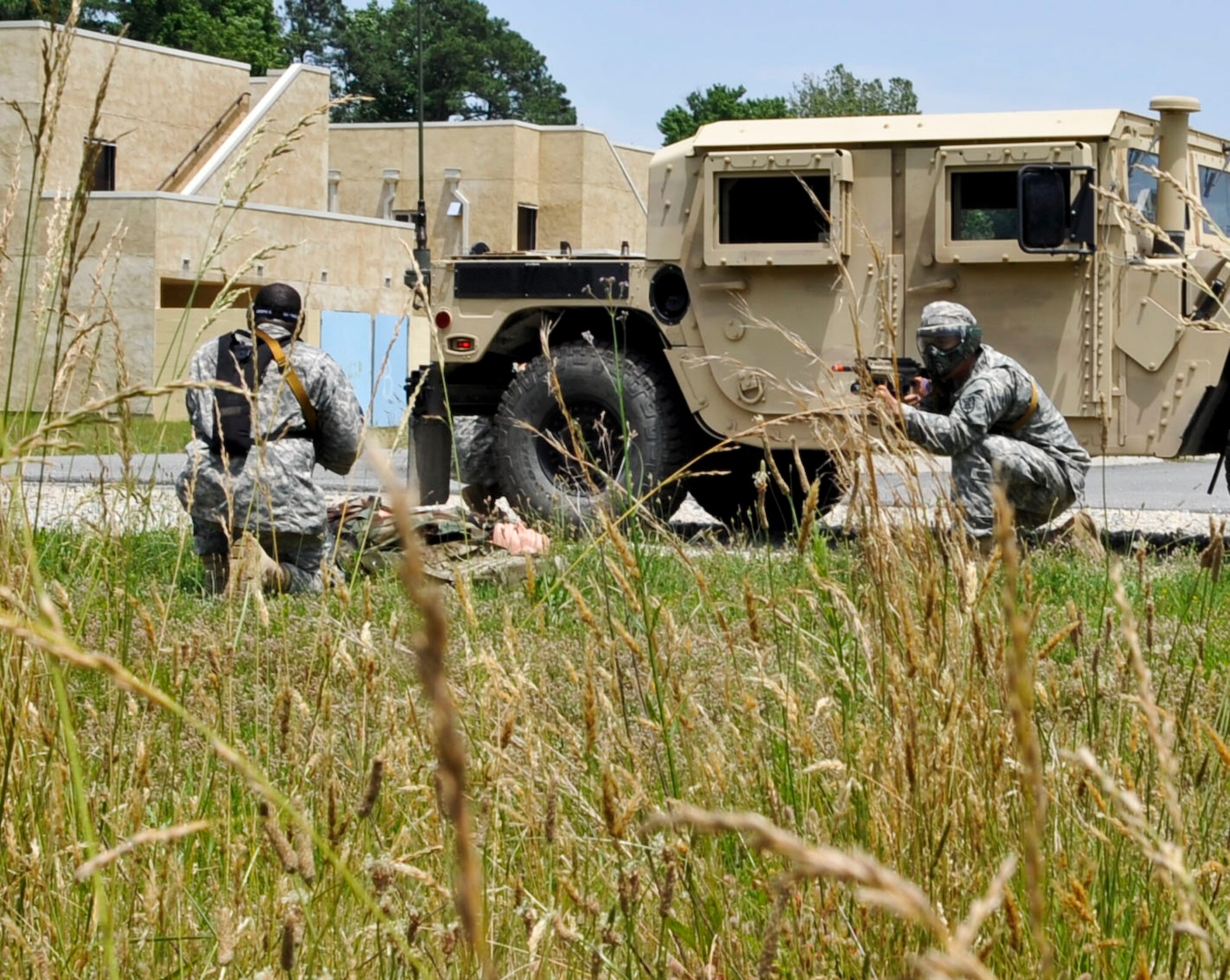 A Soldier provides cover as another Soldier performs first aid on a simulated casualty during a training scenario at the Naval Weapons Station Yorktown, Va., during a counter improvised explosive device training course, June 13, 2013. Soldiers spent three days learning about different types of explosive devices, how to identify them and what to do if they encounter one. (U.S. Air Force photo by Staff Sgt. Wesley Farnsworth / Released)