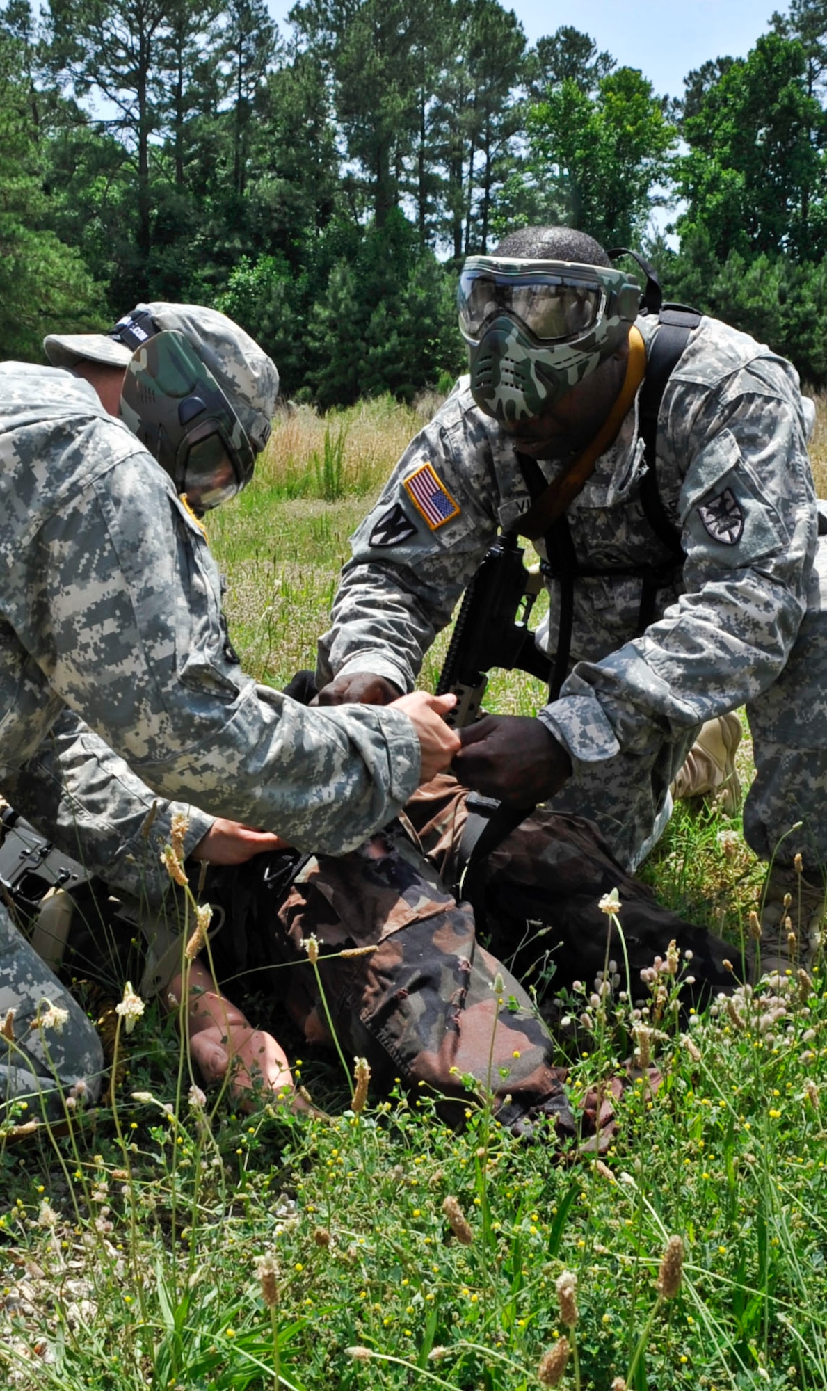 Soldiers with the 271st Movement Control Team demonstrate their combat life-saving skills on a simulated casualty during a training scenario at Naval Weapons Station Yorktown, Va., during a counter improvised explosive device class, June 13, 2013. Soldiers spent three days learning about different types of explosive devices, how to identify them and what to do if they encounter one. (U.S. Air Force photo by Staff Sgt. Wesley Farnsworth / Released)