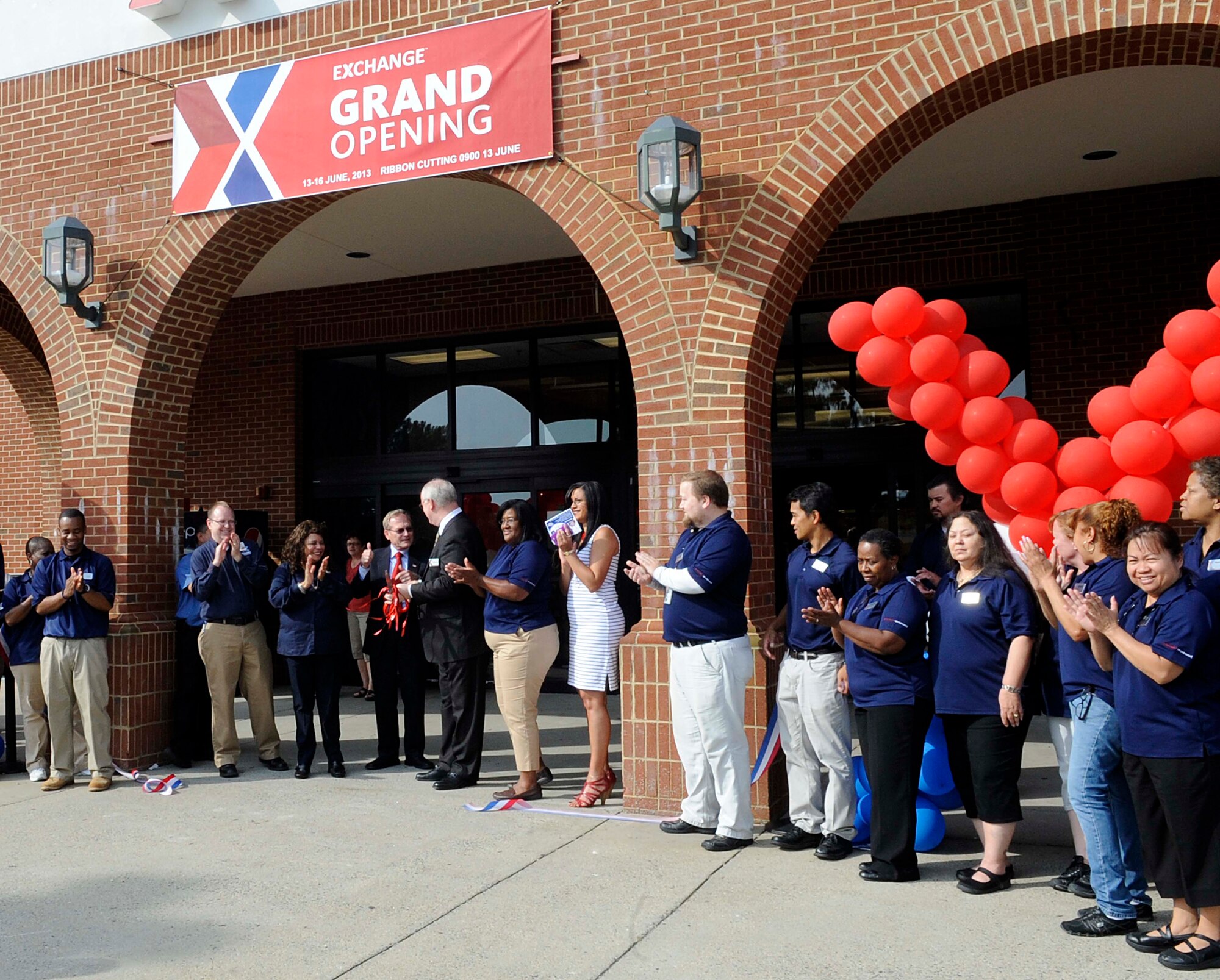 Members of Army and Air Force Exchange and onlookers celebrate at the grand opening of the newly renovated Exchange at Fort Eustis, Va., June 13, 2013. The updated Exchange features new additions to the food court, the main store, clothing sales and all of the servicing operations in the Exchange.  (U.S. Air Force photo by Staff Sgt. Dana Hill/Released)